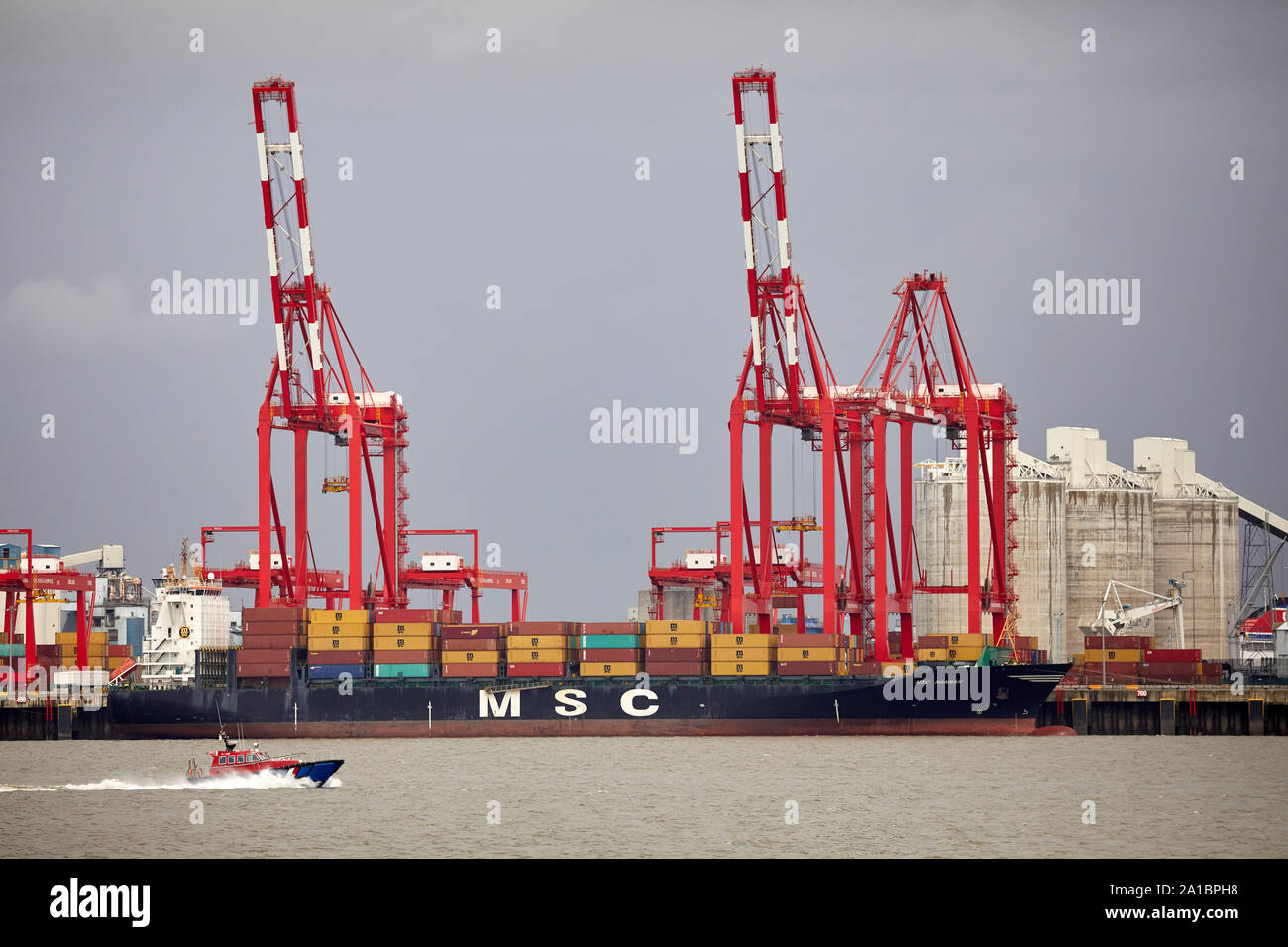 Large cargo container ship unloading at  Hornby Dock, Port of Liverpool, Bootle from the Irish Sea into the River Mersey estuary Stock Photo