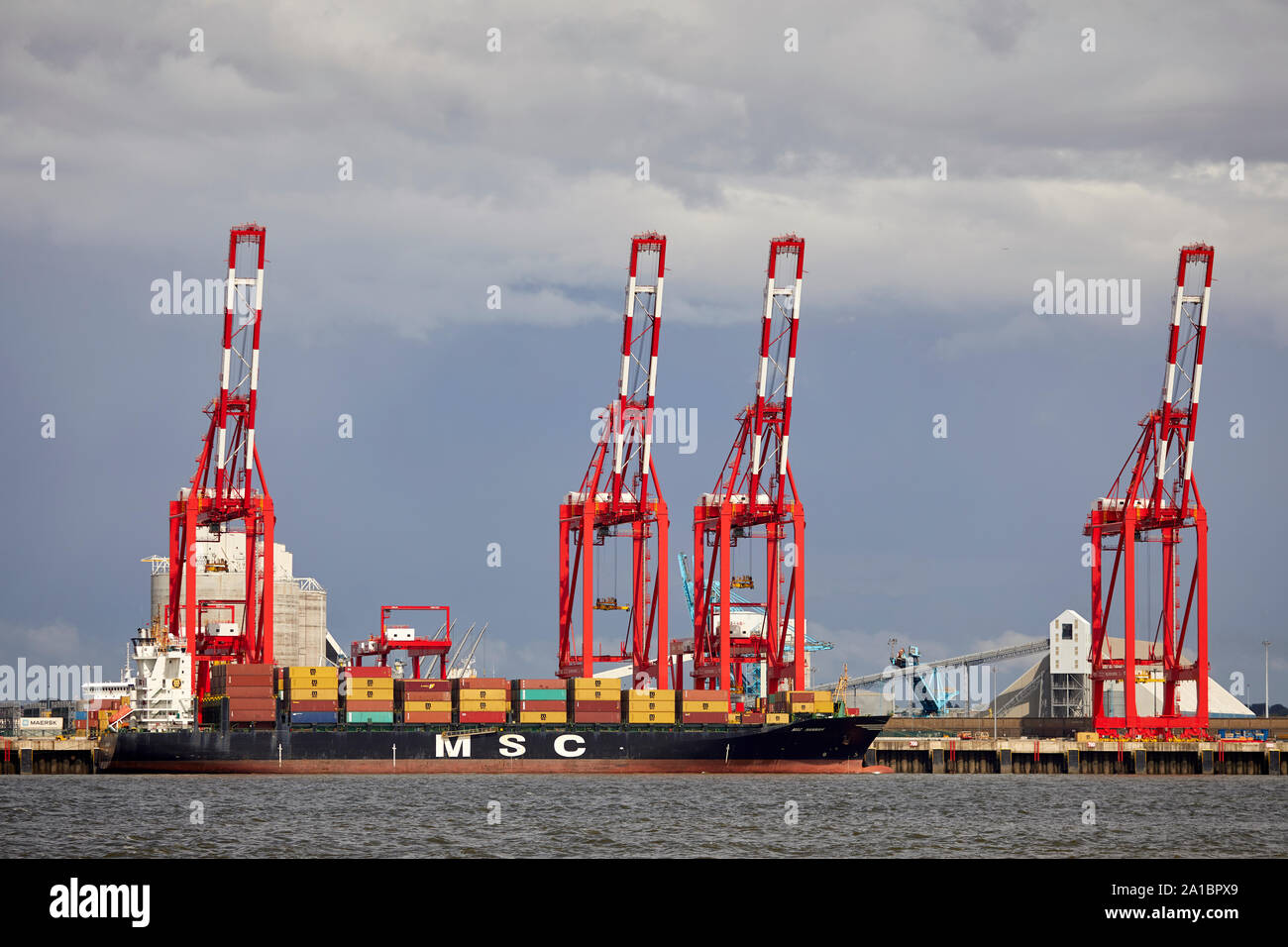 Large cargo container ship unloading at  Hornby Dock, Port of Liverpool, Bootle from the Irish Sea into the River Mersey estuary Stock Photo