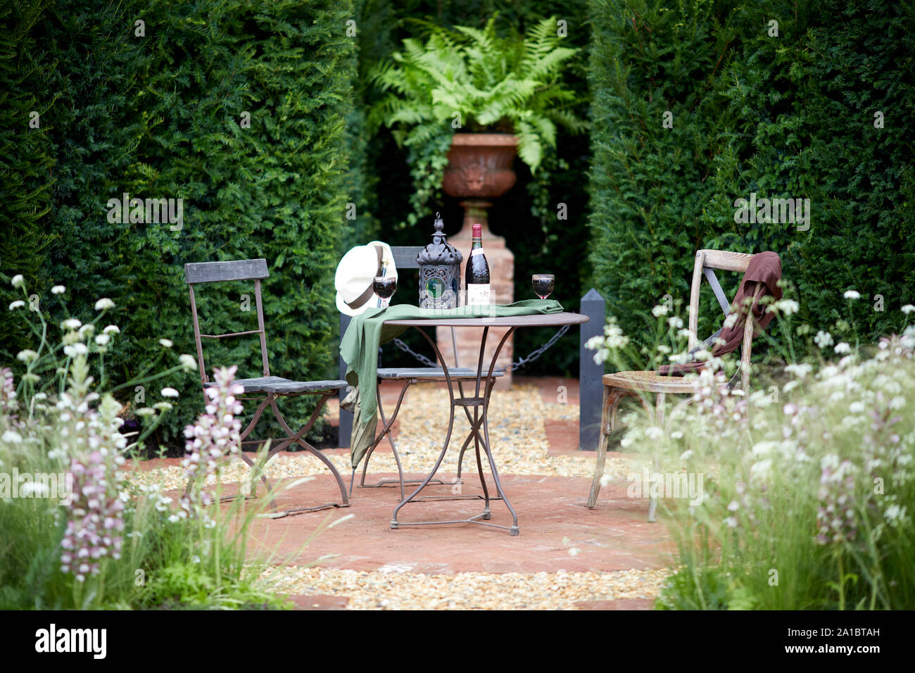 Typical english garden with small table and outdoor chairs seating area Stock Photo