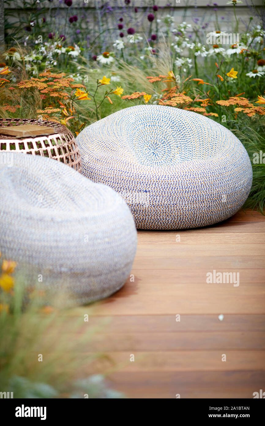 Modern relaxing chairs seating on decked area of modern garden Stock Photo
