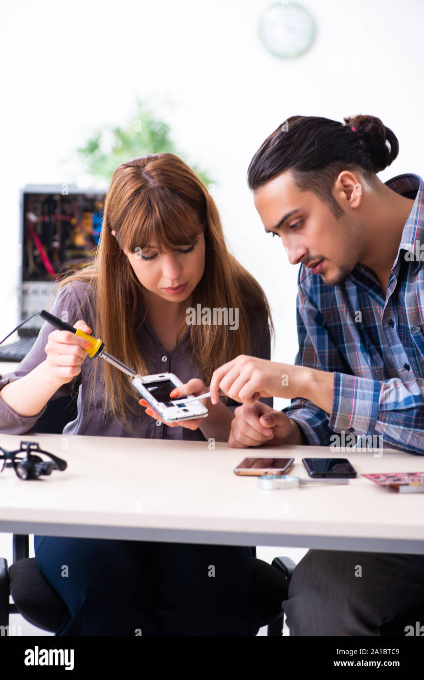 The two technicians working at computer warranty center Stock Photo
