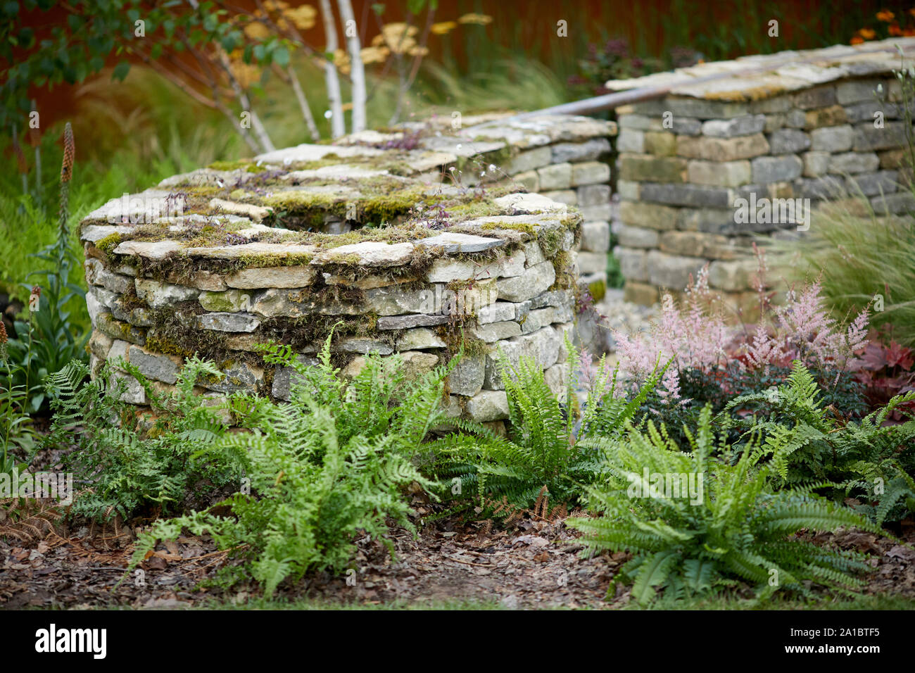 Attractive dry stone wall with moss in ornate shape Stock Photo