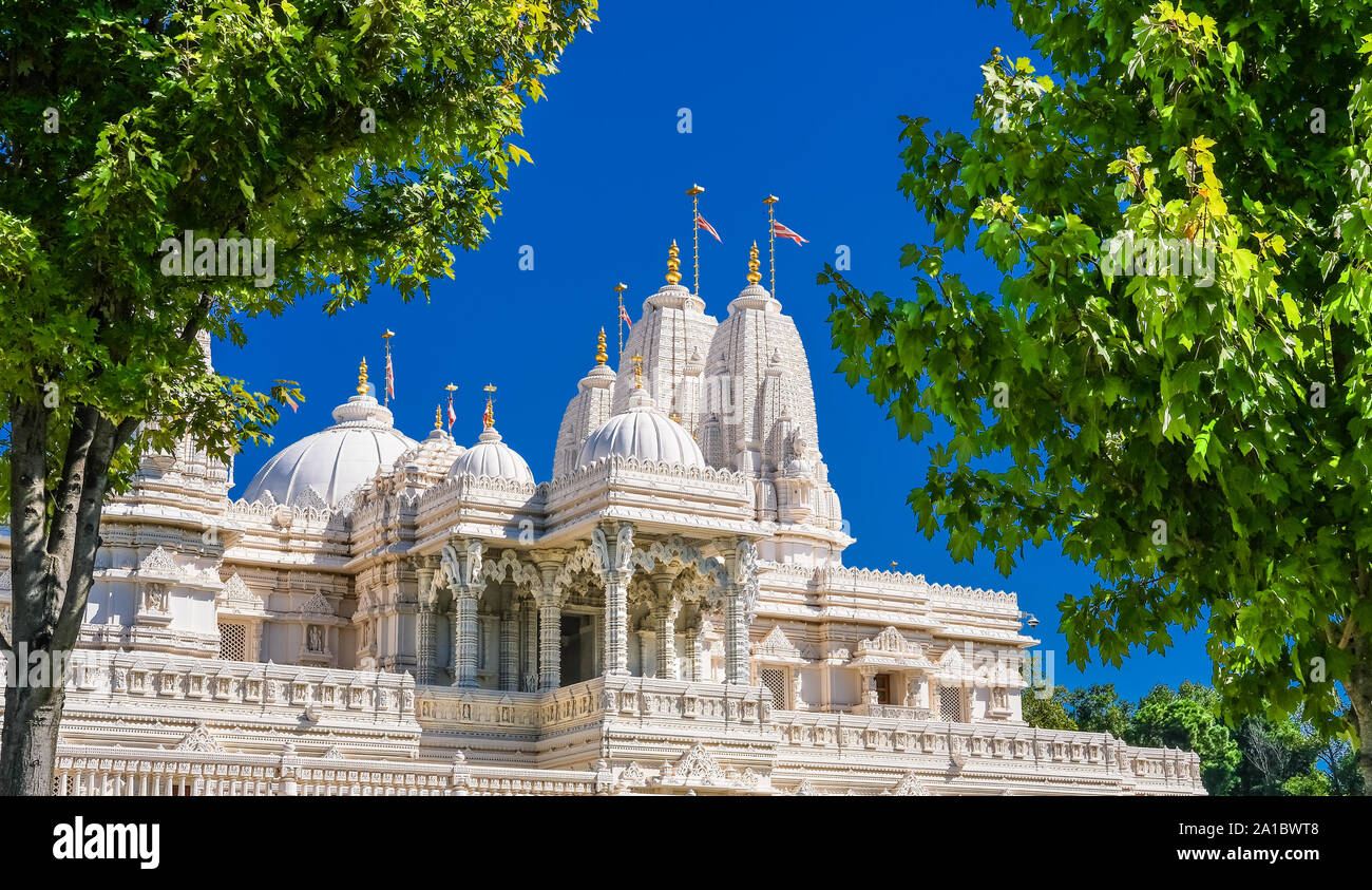 Hindu Mandir against a blue sky between green trees Stock Photo - Alamy