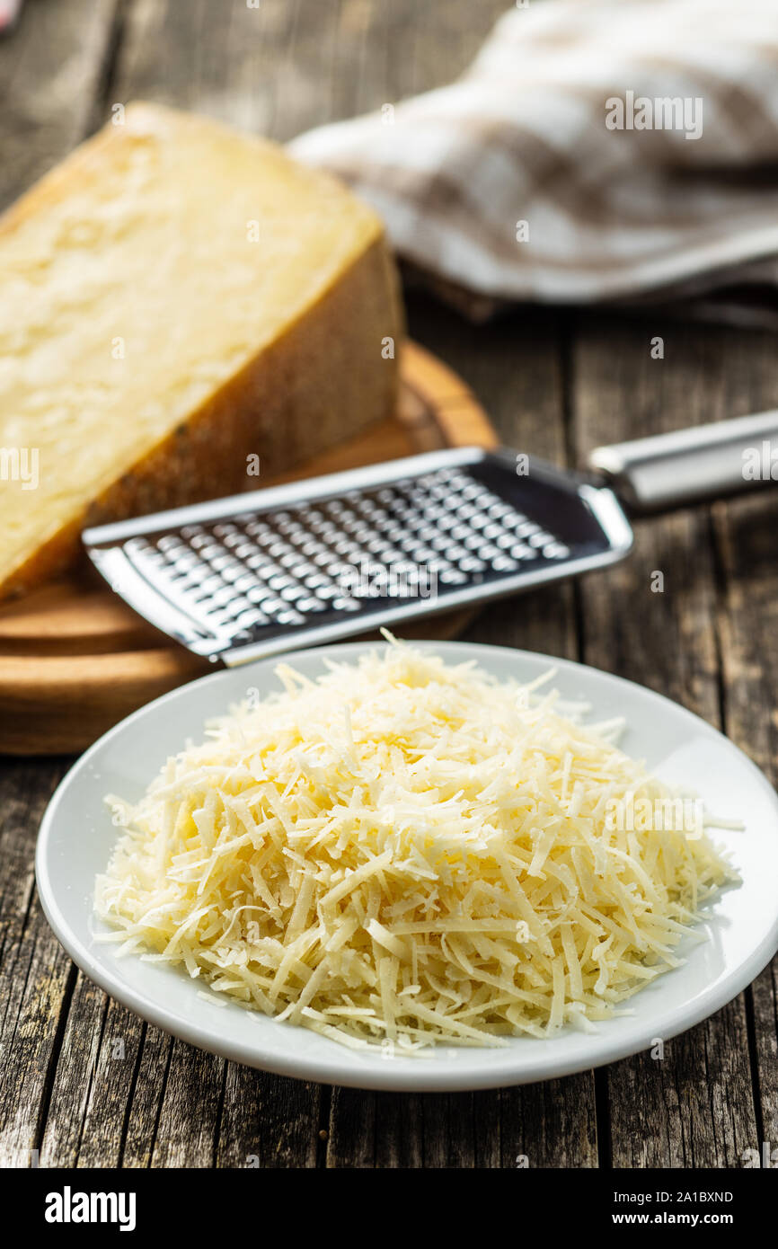 Grated cheese in plastic container on table Stock Photo - Alamy