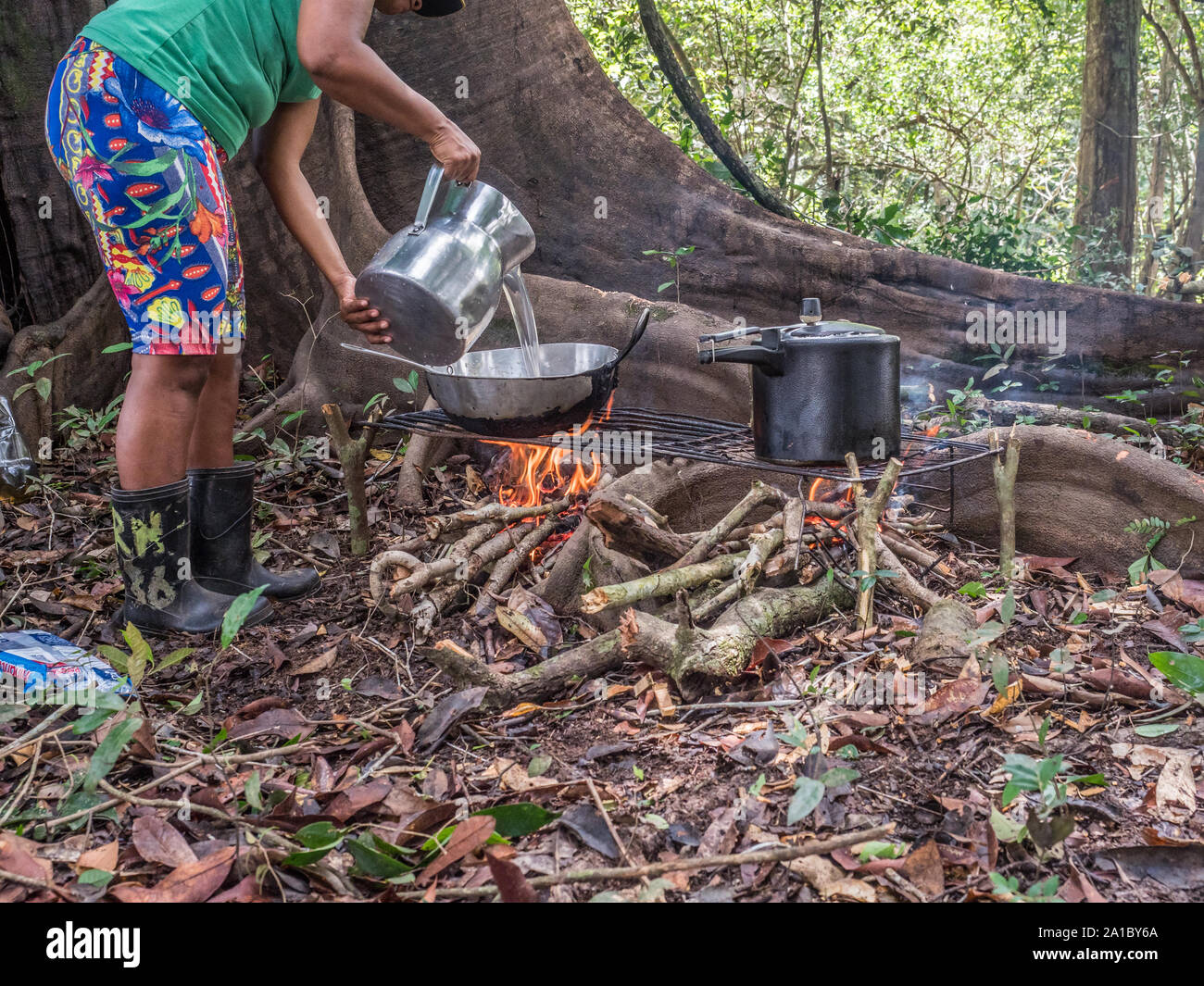 Lagoon, Brazil - November  27, 2017: Brazilian  woman cooking on the fireplece on the camp in the amazons jungle Stock Photo