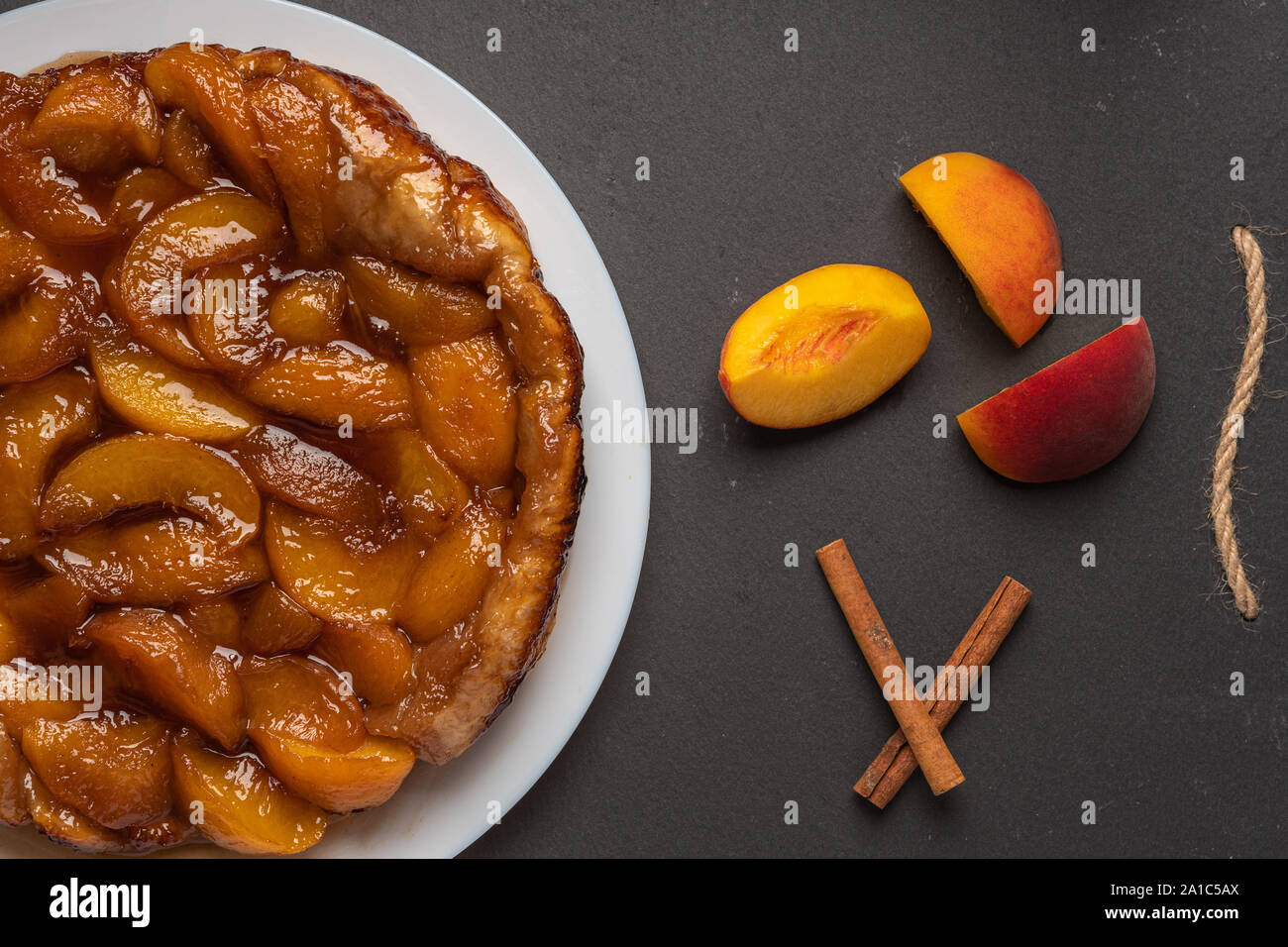 Tarte Tatin With Peaches And Caramel On A White Plate On A Dark