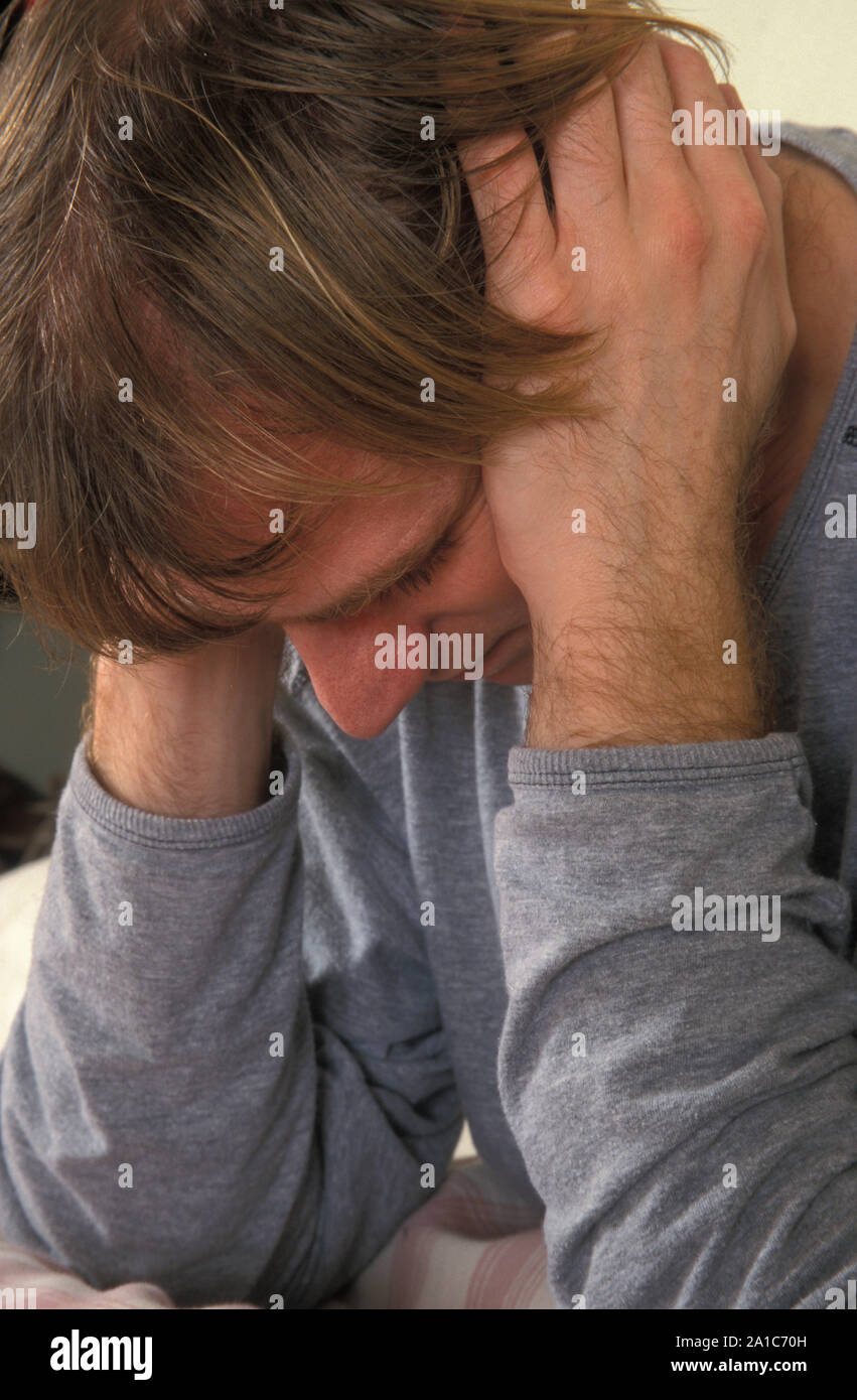 depressed young man with head in hands Stock Photo