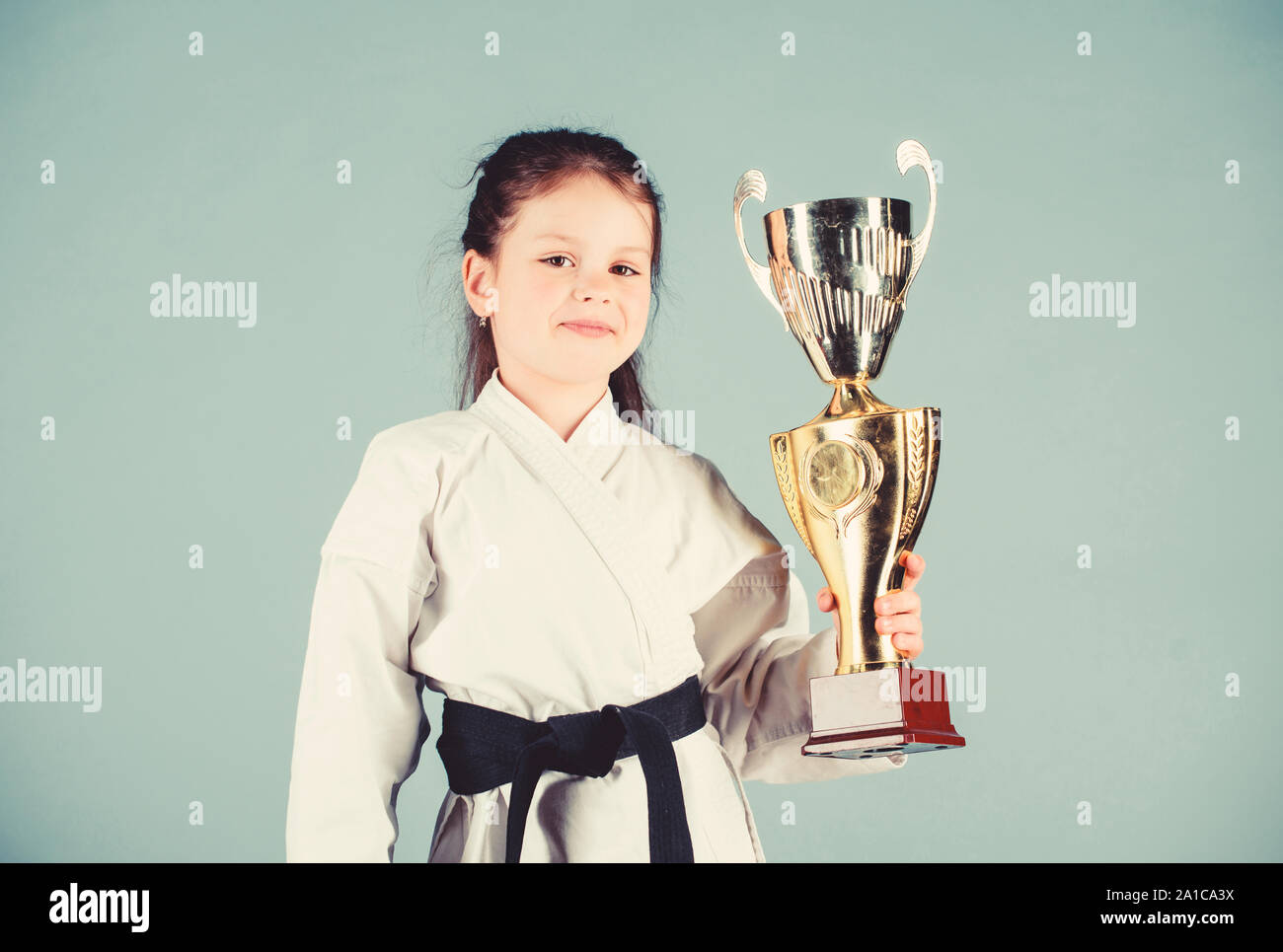 winner little girl in gi sportswear. practicing Kung Fu. happy