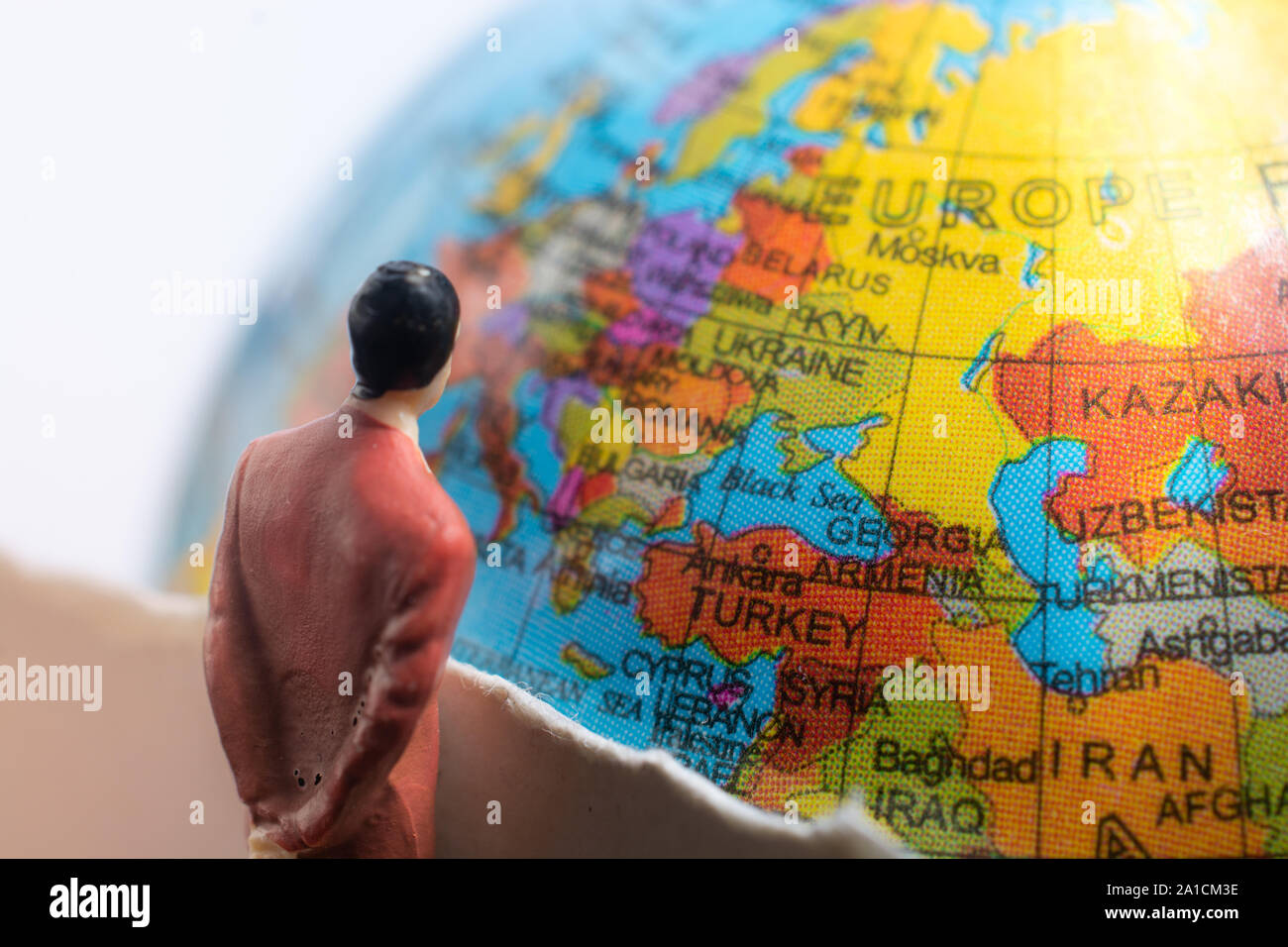 Businessman figure observing a globe model from close-up Stock Photo