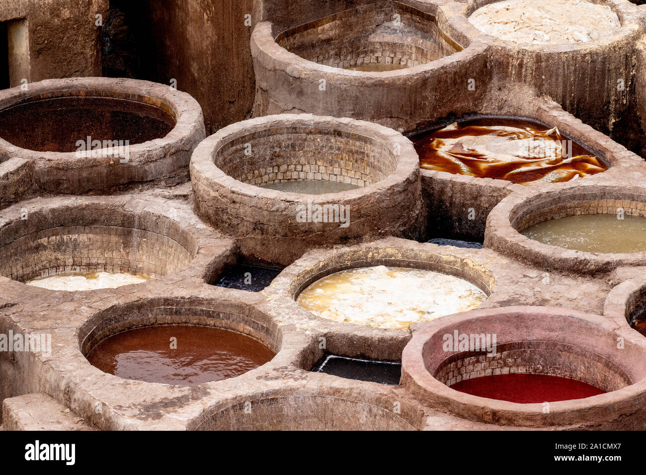 Vats filled with various dyes at a tannery in Fes, Morocco which will be used to dye the hides various tones Stock Photo