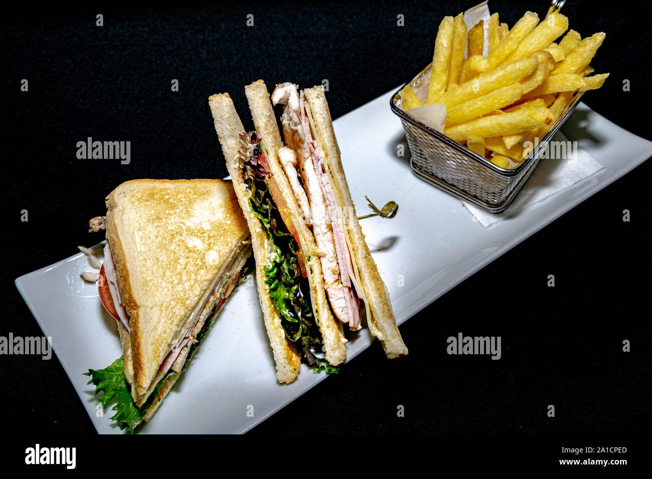 a tasty toasted club sandwich filled with grilled chicken, turkey ham