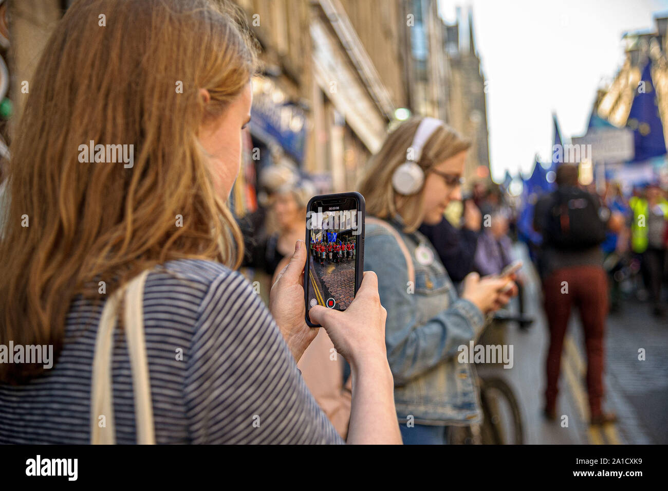 Bystanders are seen taking photos of the protesters on their phones during the demonstration.Organized by European Movement in Scotland as well as Edinburgh For Europe, protesters took to the streets of Edinburgh to demand MPs revoke Article 50 to prevent a no-deal and that the EU shares a notion to combat climate change. Stock Photo