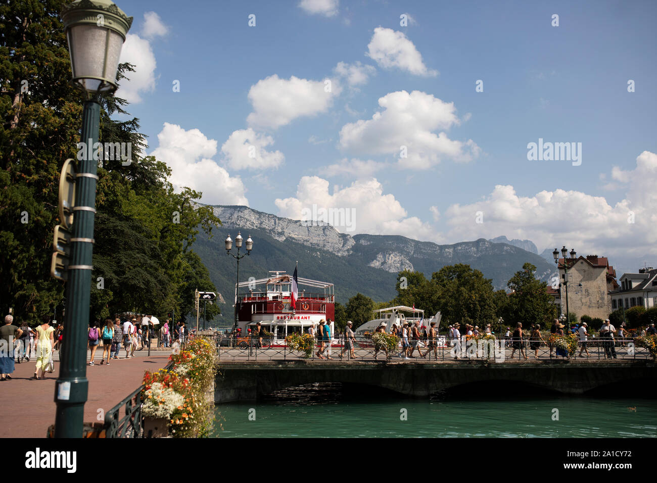 The Bateau Restaurant Le Libellule is visible behind the bridge at Quai Eustache Chappuis over Le Thiou canal in the old town of Annecy, France. Stock Photo