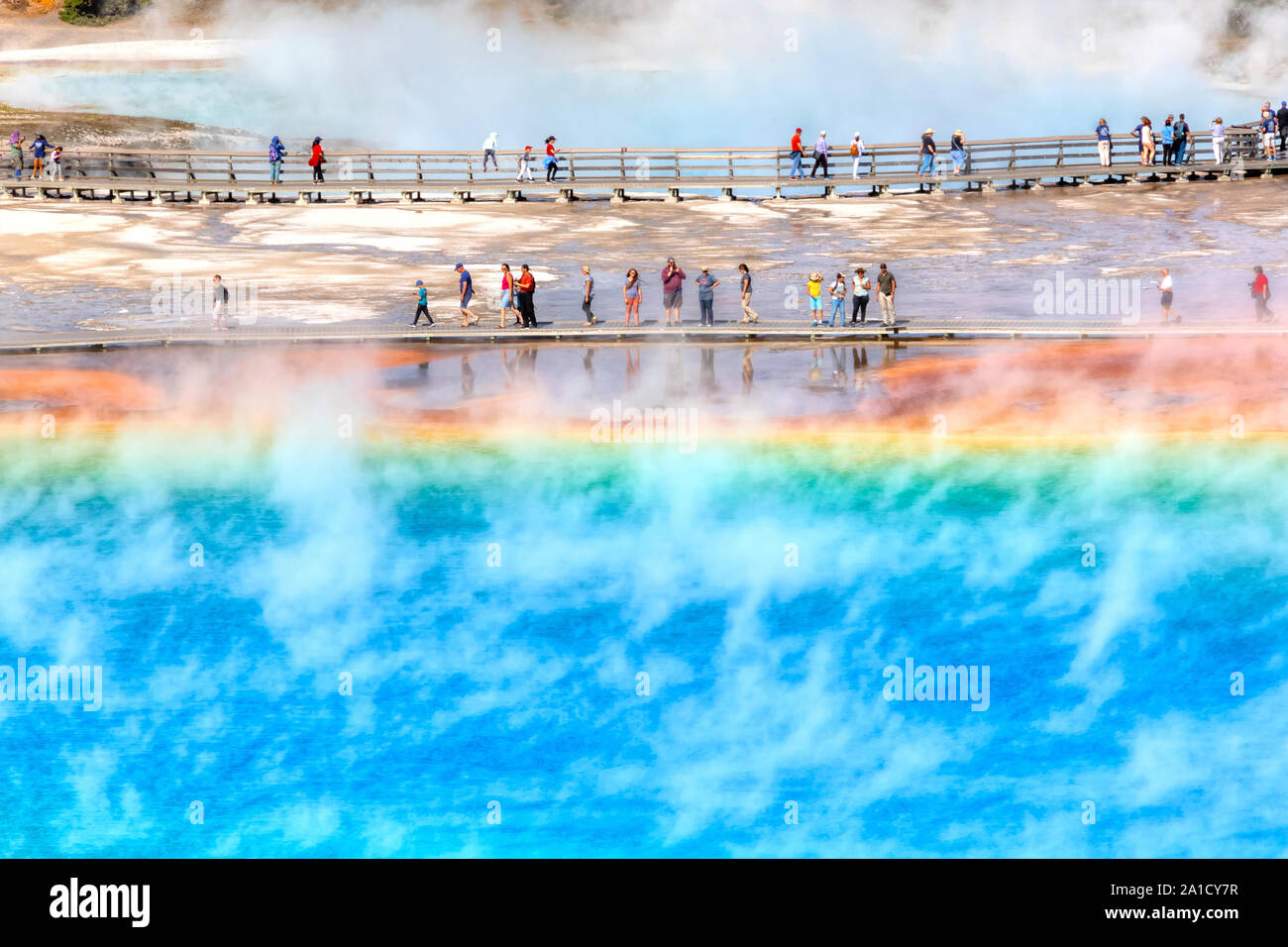YELLOWSTONE, USA - AUG 24, 2019: Tourists on the boardwalk at Grand Prismatic Spring, the largest hot spring at Yellowstone National Park. Stock Photo
