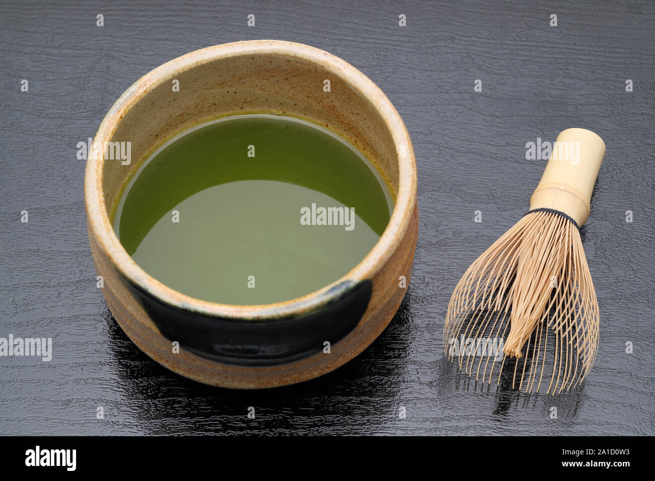 Japanese matcha green tea in a ceramic bowl with tea whisk Stock Photo