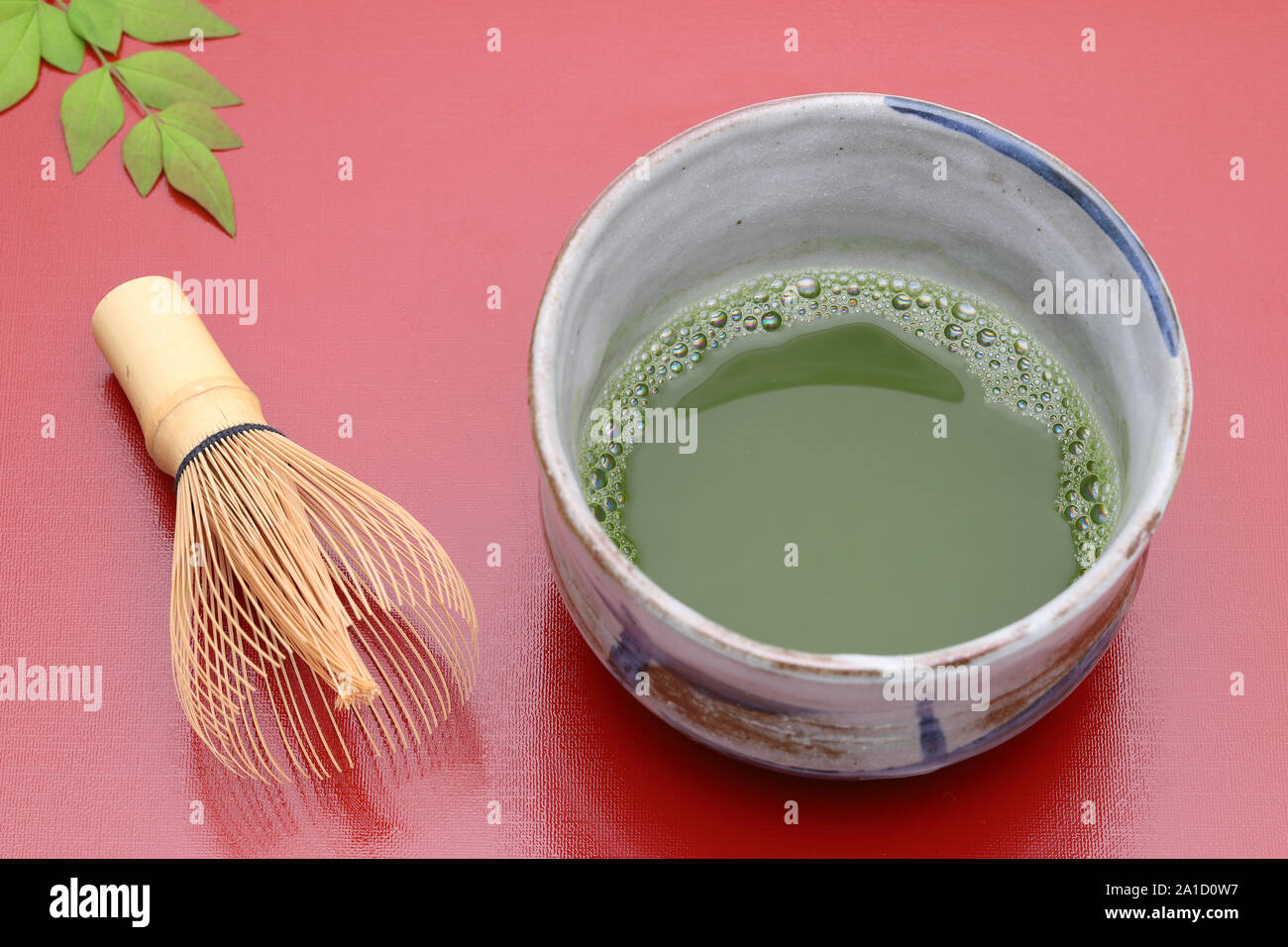 Japanese matcha green tea in a ceramic bowl with tea whisk Stock Photo