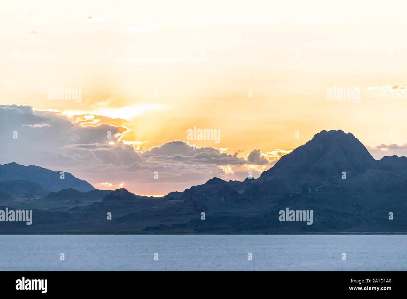 Bonneville Salt Flats landscape near Salt Lake City, Utah and silhouette mountain view and sunset behind clouds Stock Photo