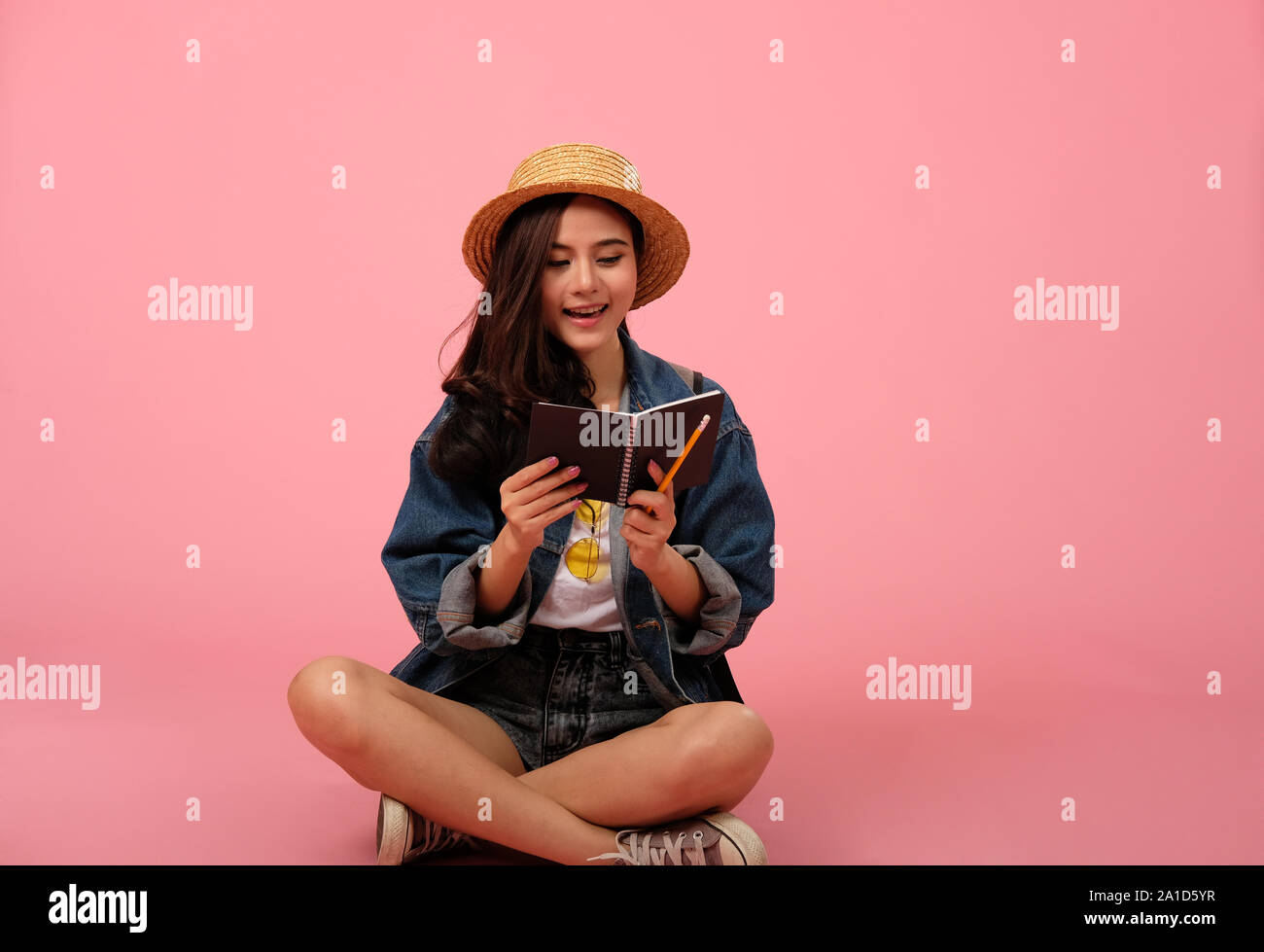 portrait of smiling young asian woman wearing jeans jacket with ...