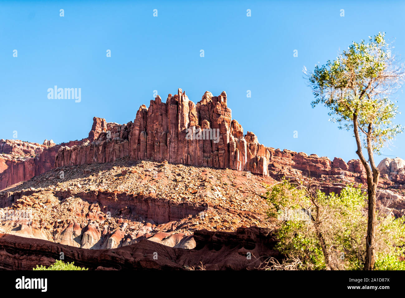 Fluted Wall butte mesa cliff low angle view in Capitol Reef National Monument with red shapes formations on canyon in Utah Stock Photo