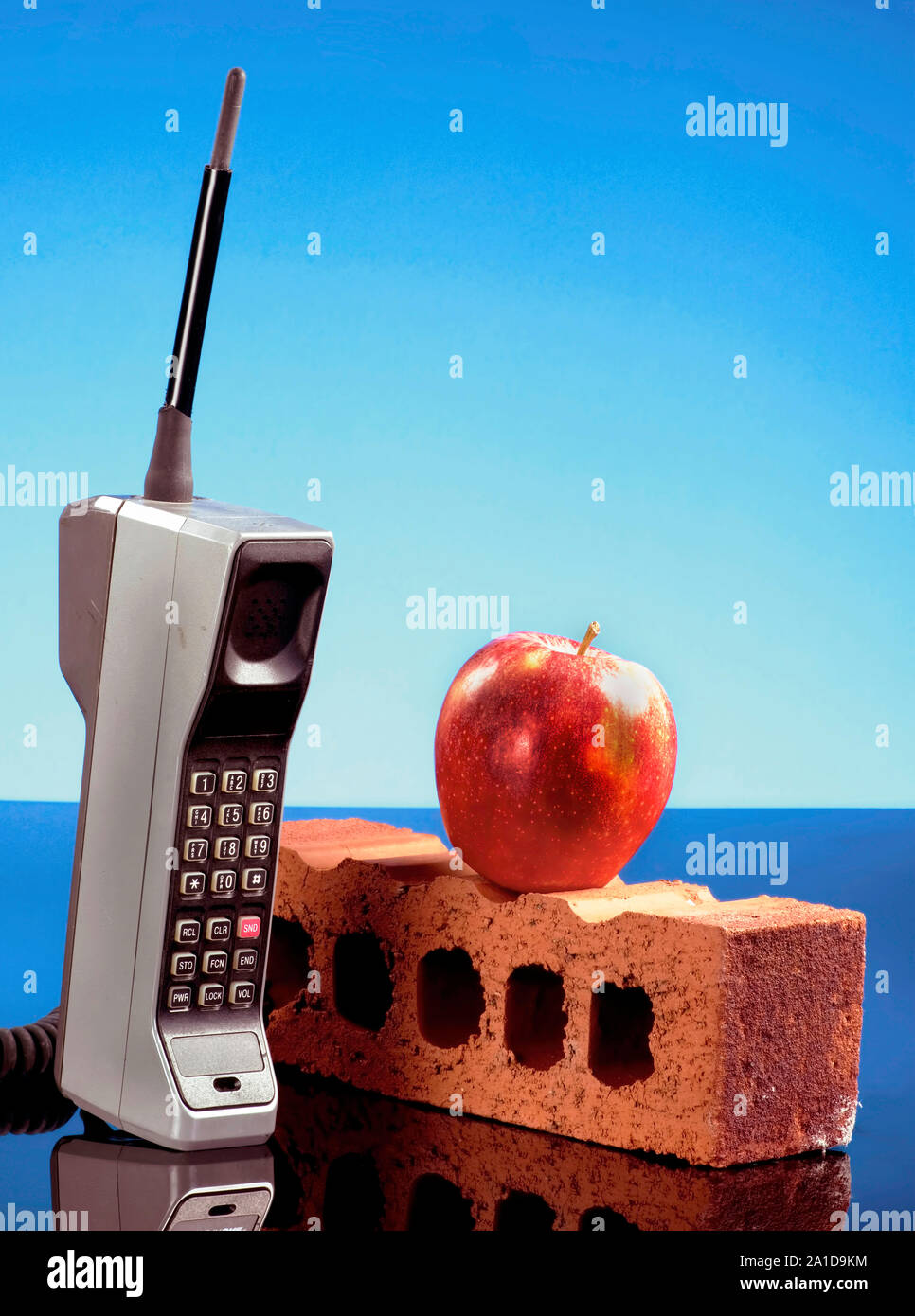 Old cell phone called the brick phone with a red apple made in the early 1980's. Stock Photo