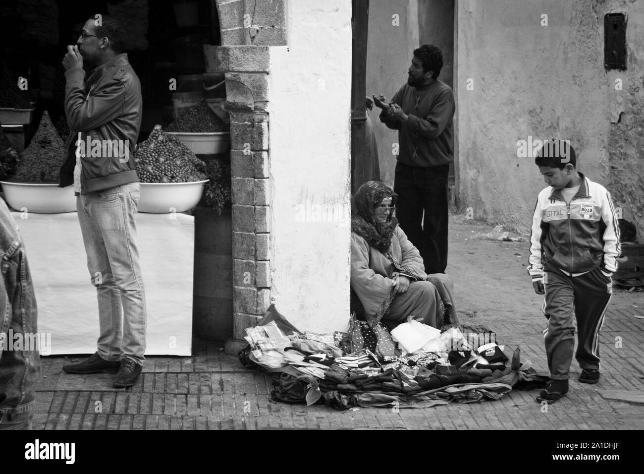 A boy looks at a woman's wares in Essaouira, Morocco, Africa Stock Photo