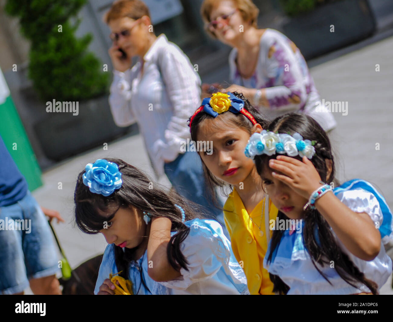 Girls in traditional costumes wearing flower headdress during the XV Intercultural Week Parade in Valladolid Stock Photo