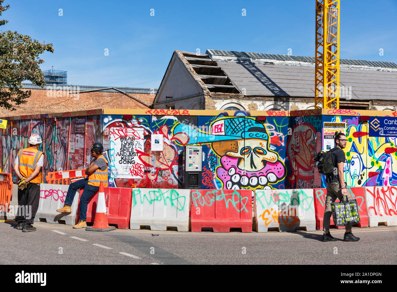 Graffiti covered architectural hoarding boards screen construction work in Hackney Wick, east London, UK. Stock Photo