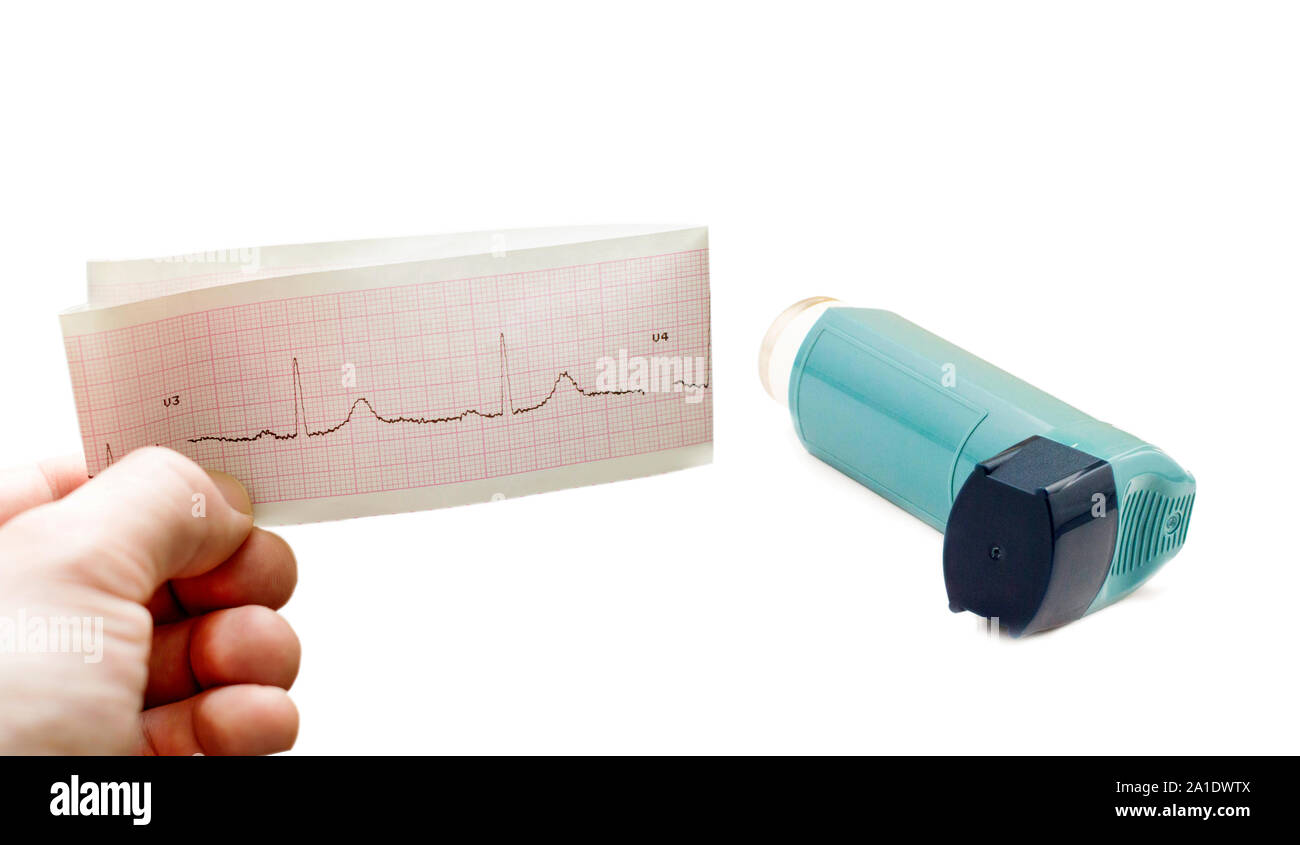 Inhaler to treat asthma and cardiogram in hand on a white background ...