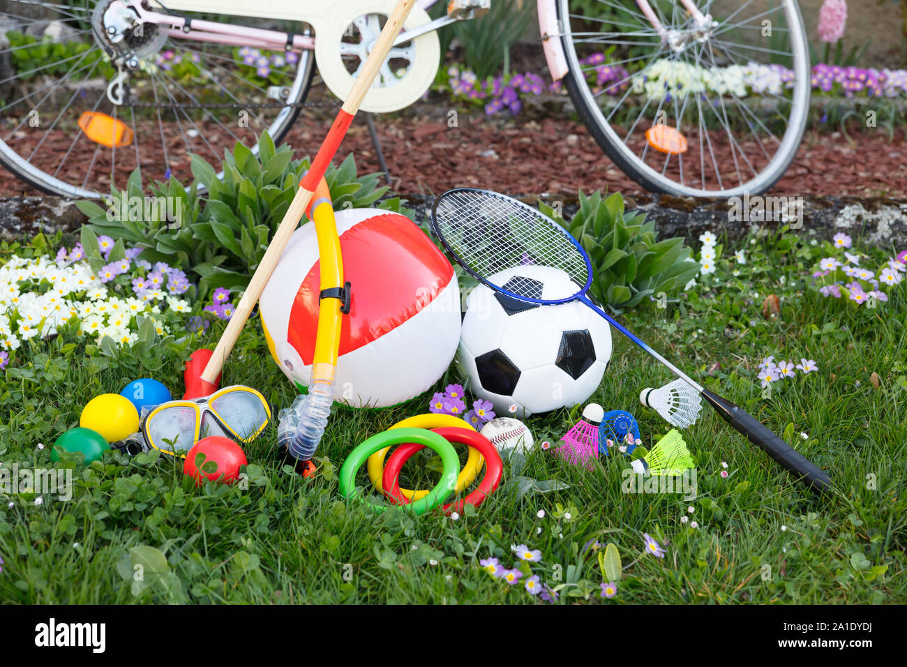spring or summer with various outdoor fun equipment, green meadow with a bicycle Stock Photo