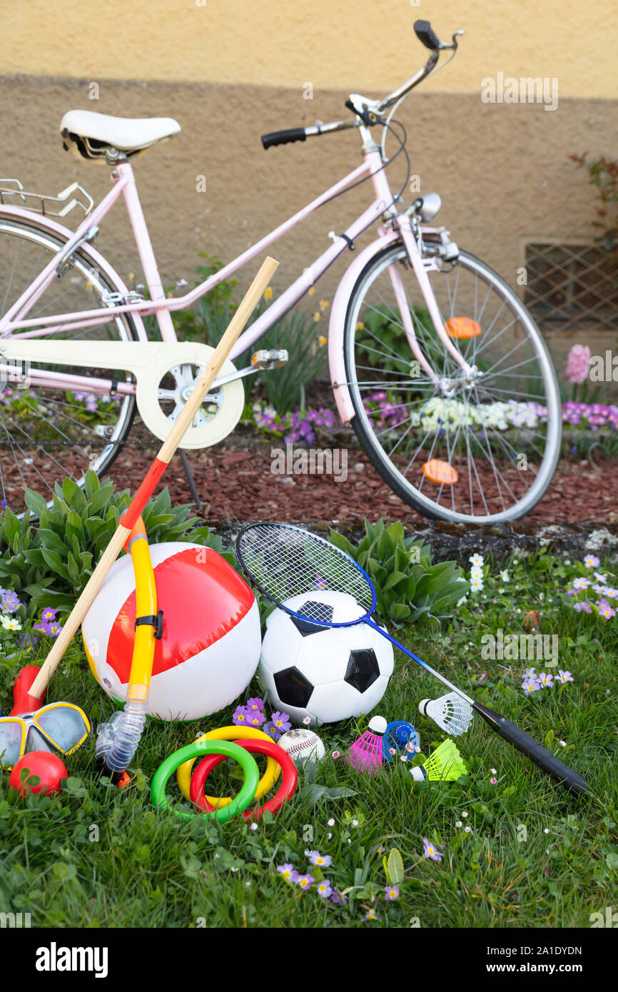 leisure equipment on a green meadow with a pink bicycle Stock Photo