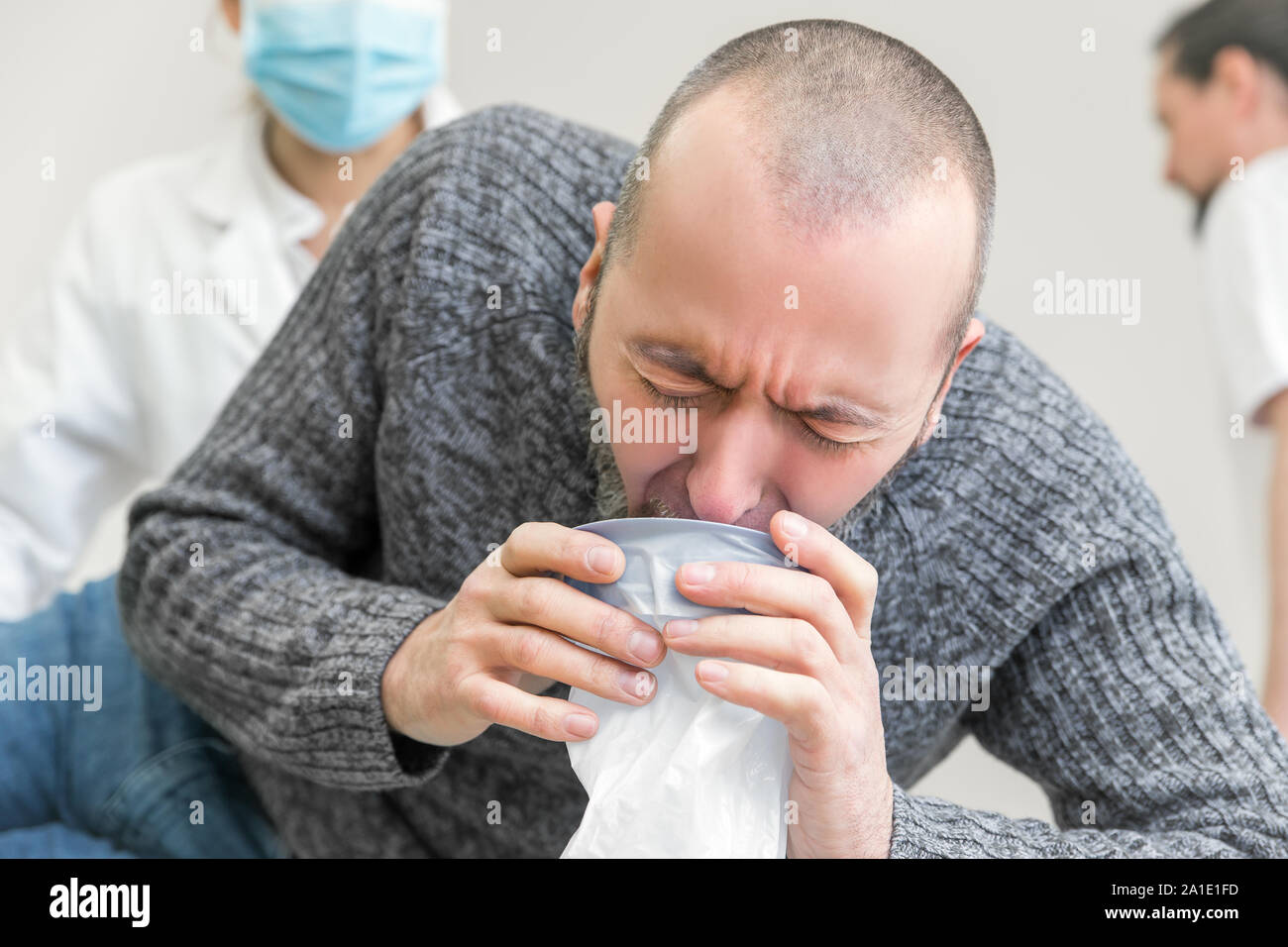 male patient in clinic is vomiting in a plastic bag Stock Photo Alamy