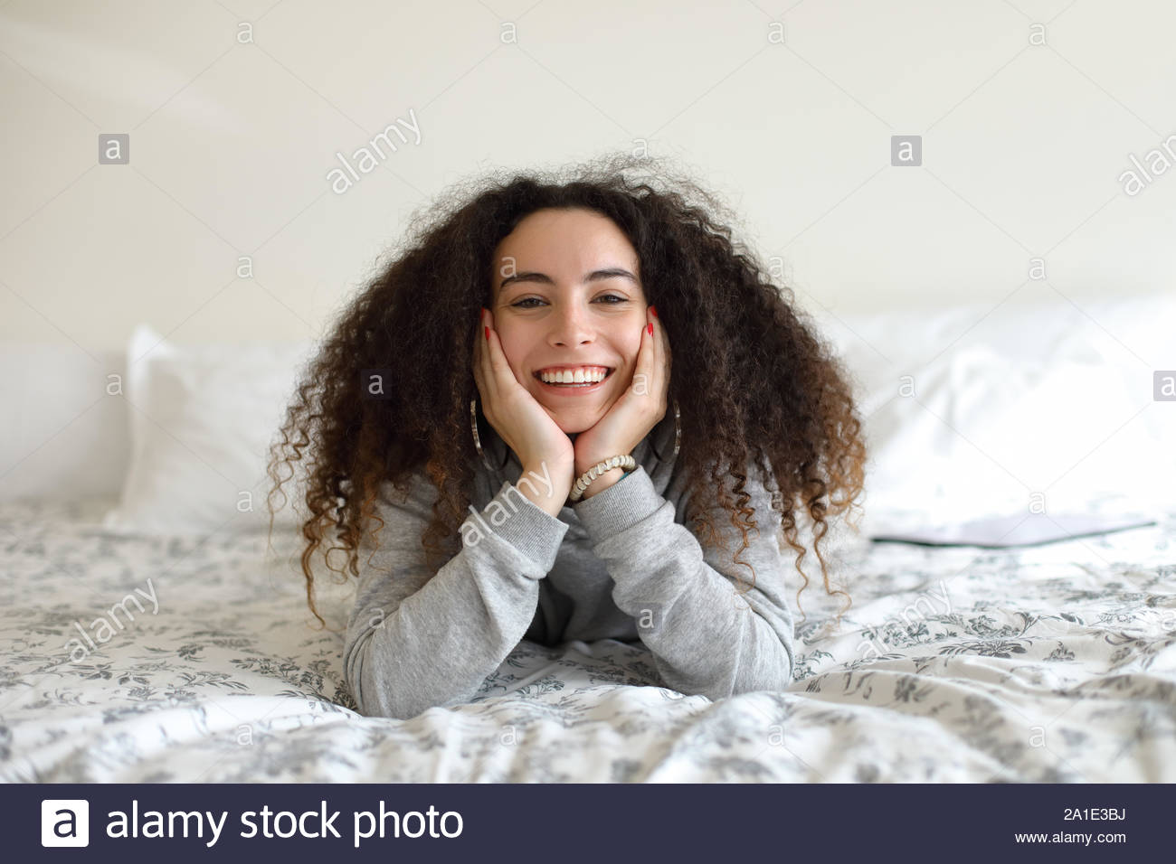 Happy Joyful Girl Portrait Relaxing In Bed At Home Curly Hair