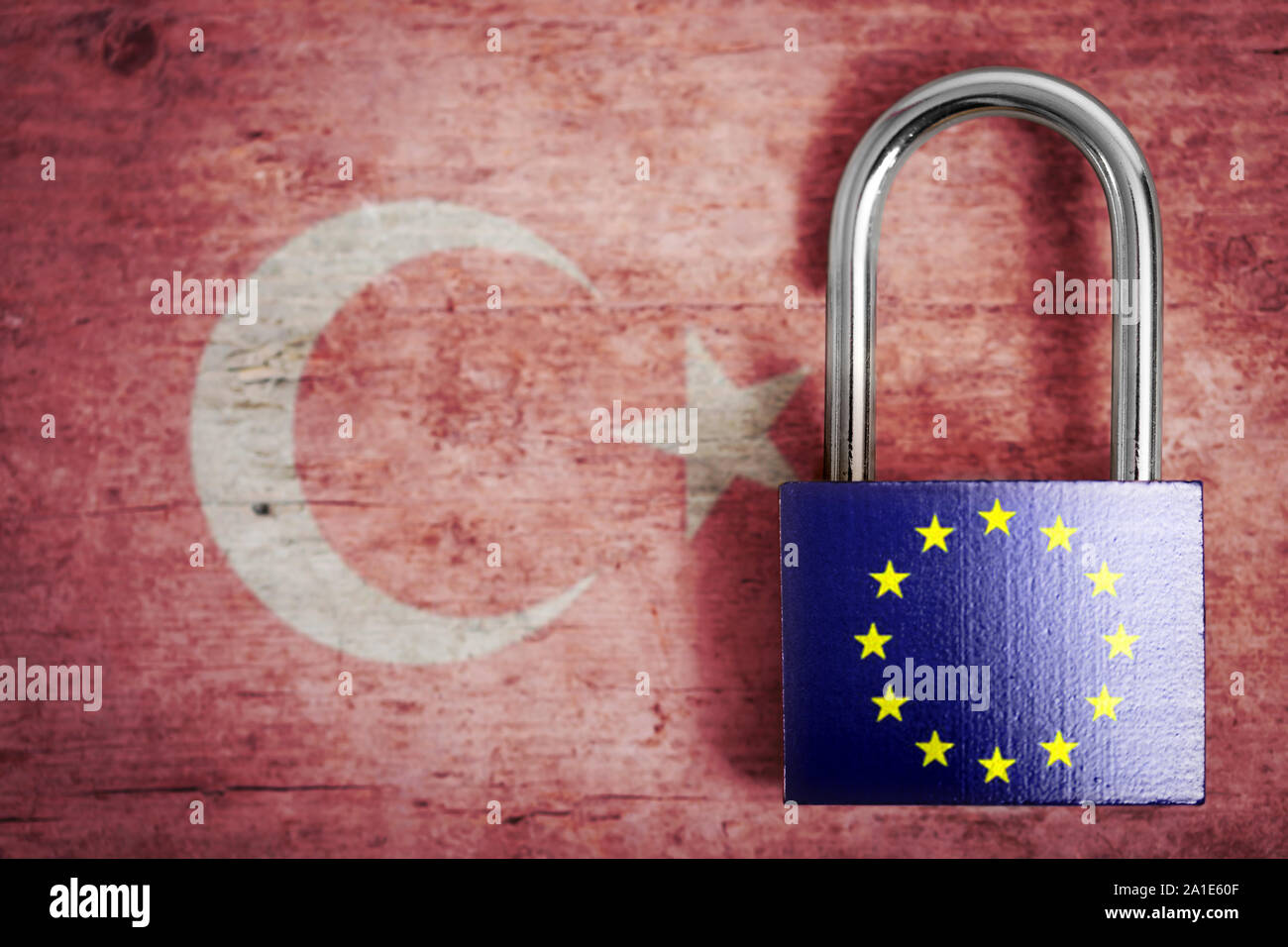 locked padlock with flag of european union in front of a wooden background with turkish flag Stock Photo