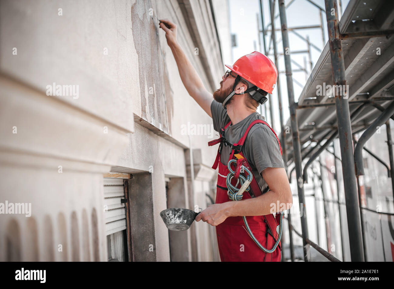 Construction mason worker plastering old building wall using cement