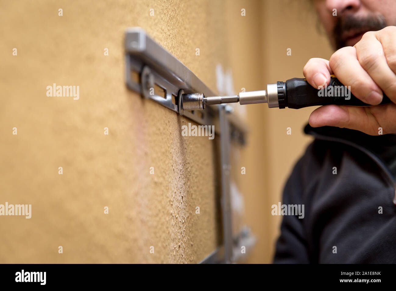 Man installing mount tv on the wall at home, closeup Stock Photo