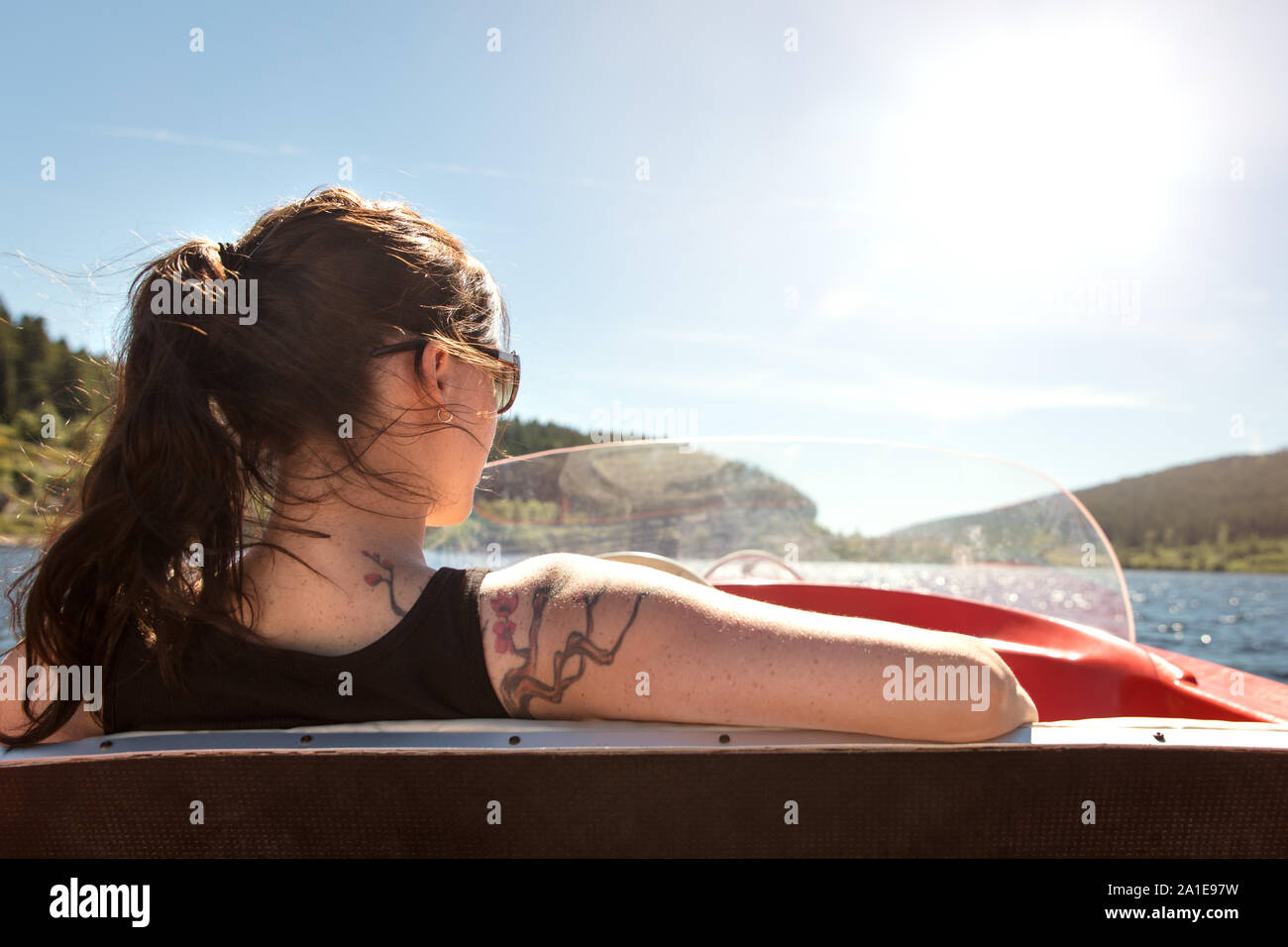 Backview from a woman in a boat, boating lake and blue sky with copyspace Stock Photo