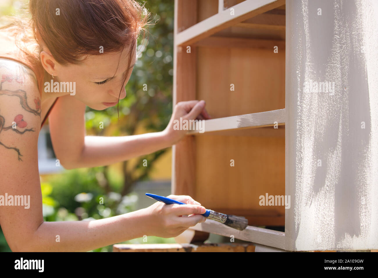 Woman Is Painting An Old Dresser Outdoor In White And Grey Shabby