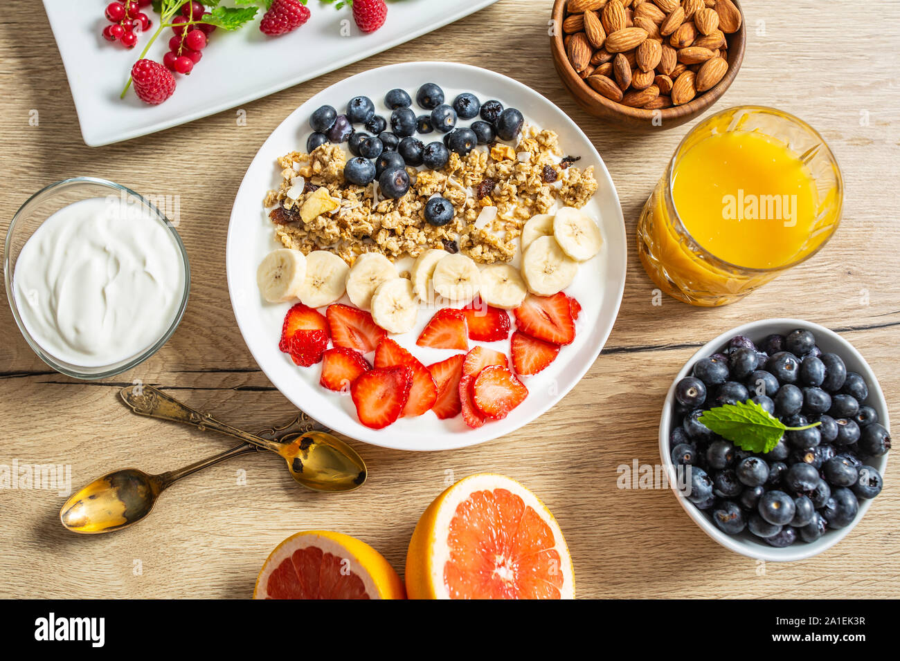 Healthy breakfast served with plate of yogurt muesli blueberries strawberries and banana. Stock Photo