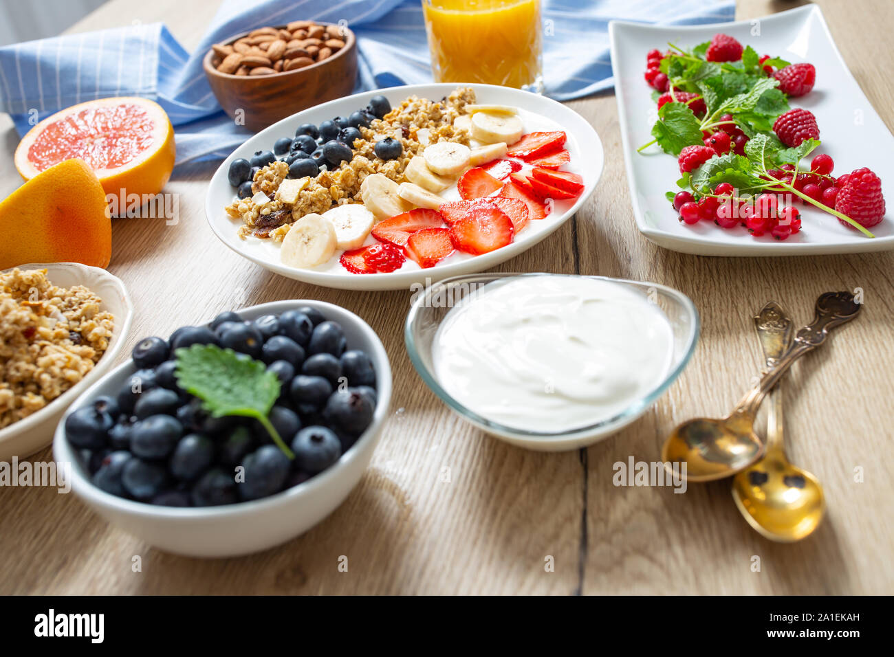 Healthy breakfast served with plate of yogurt muesli blueberries strawberries and banana. Stock Photo