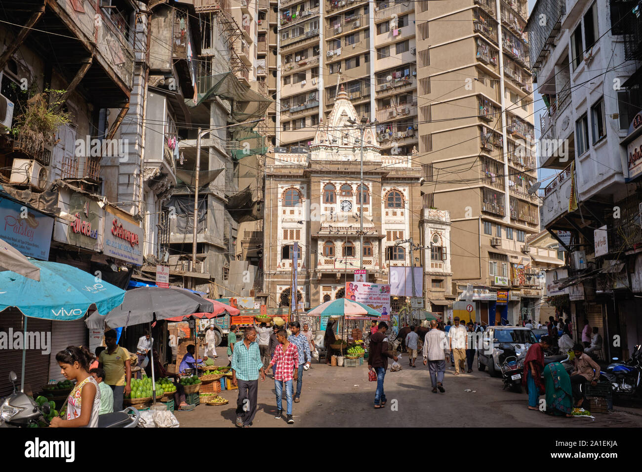 People in a busy market lane in Gujarati-dominated Bhuleshwar area, Mumbai, India, Ram Temple and a high rise apartment building in the background Stock Photo