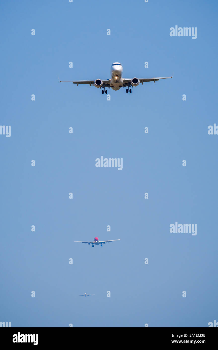 Passenger airplane flying in blue sky, front view Stock Photo - Alamy