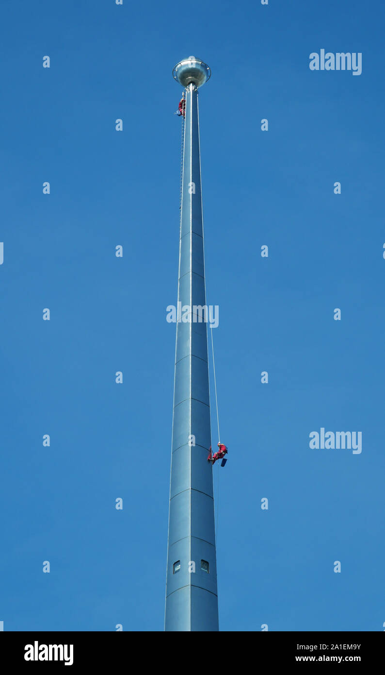 Dangerous Occupation - Cleaners at work at the top of one of the two Petronas Towers in Kuala Lumpur Stock Photo
