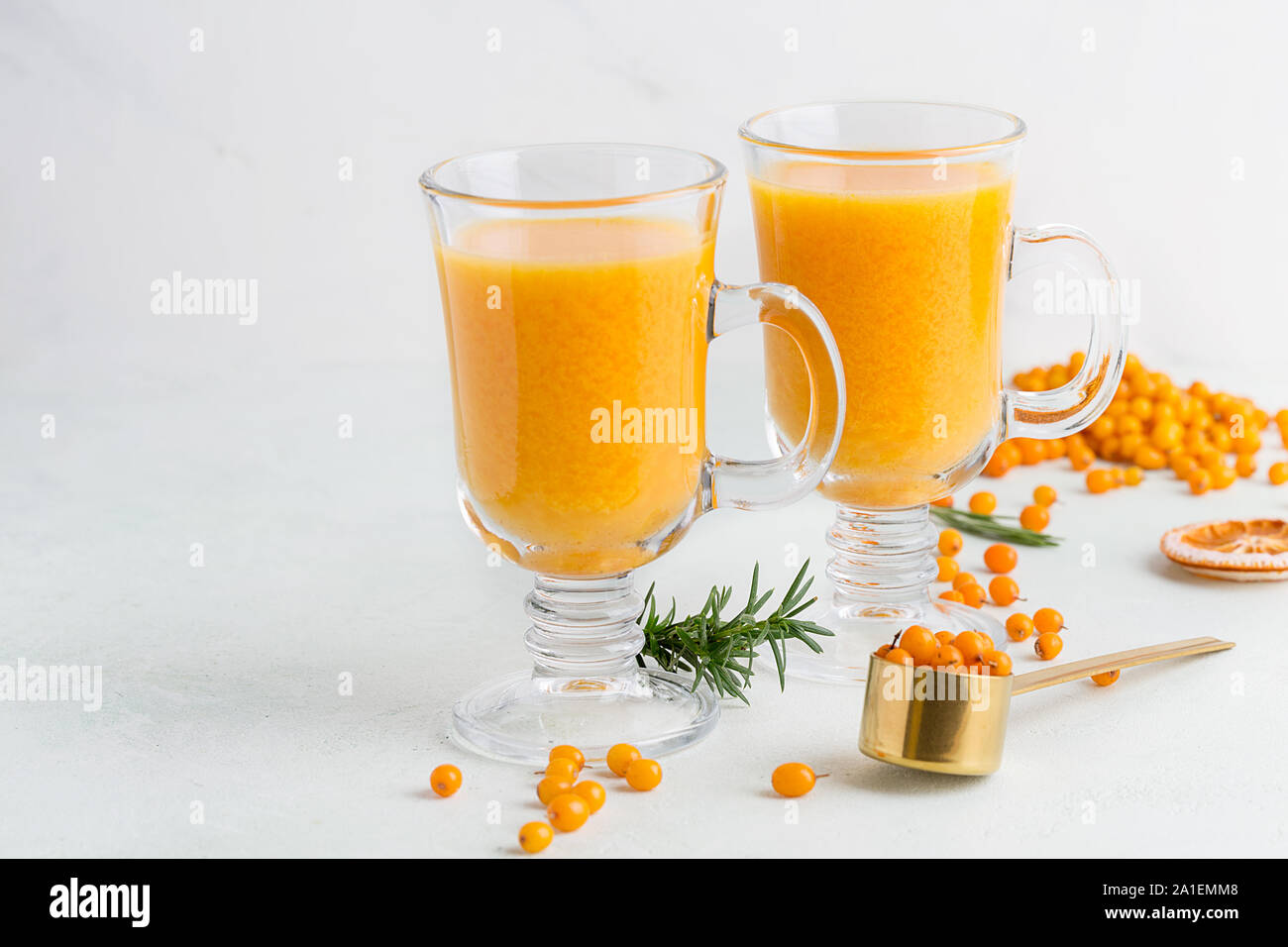 Bright hot tasty sea buckthorn drinks in glasses on white background with ingredients. Concept of autumn and winter warm drinks Stock Photo
