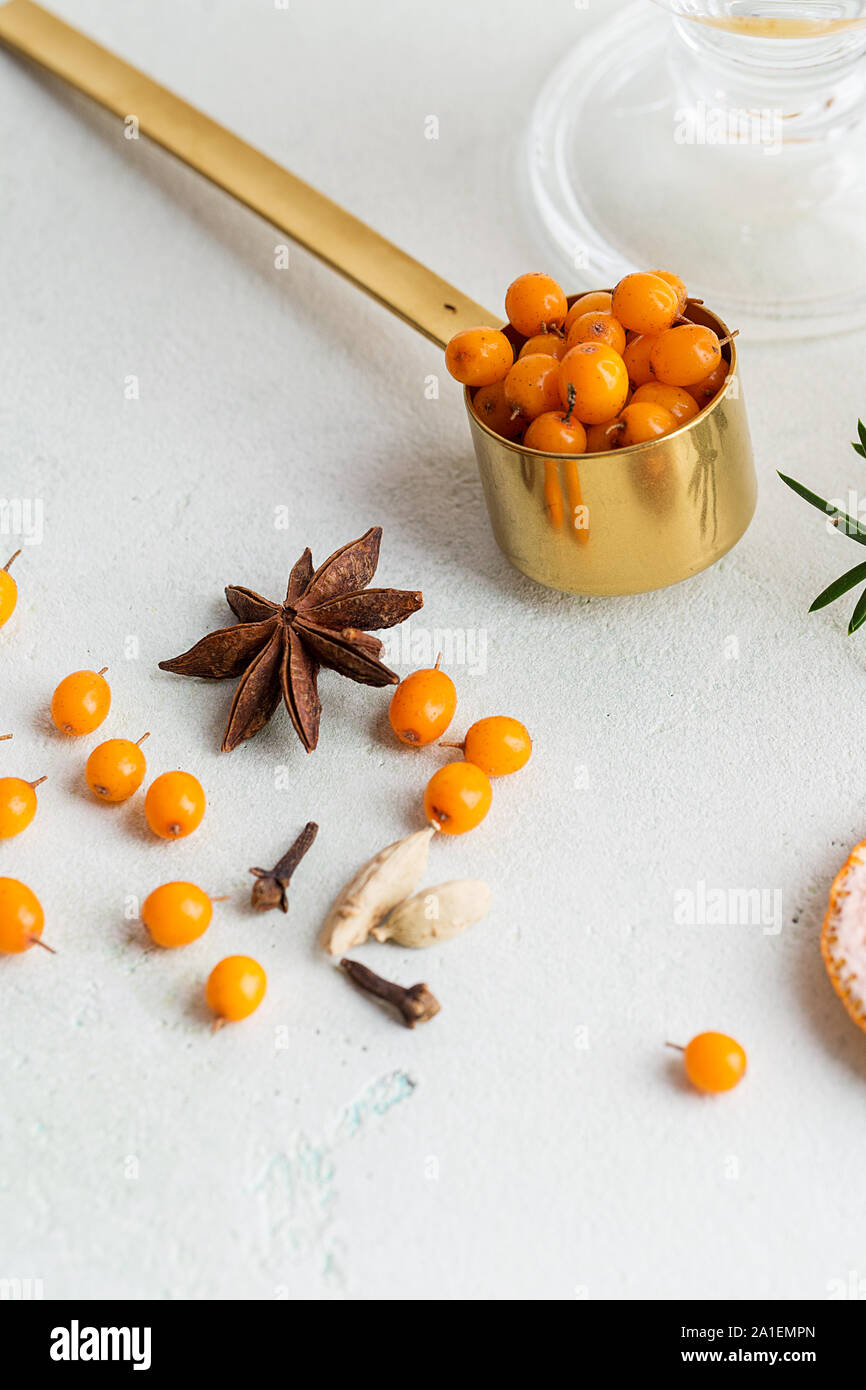 Ingredients for sea buckthorn tea on white concrete background. Concept of healthy recipe for warm beverages Stock Photo
