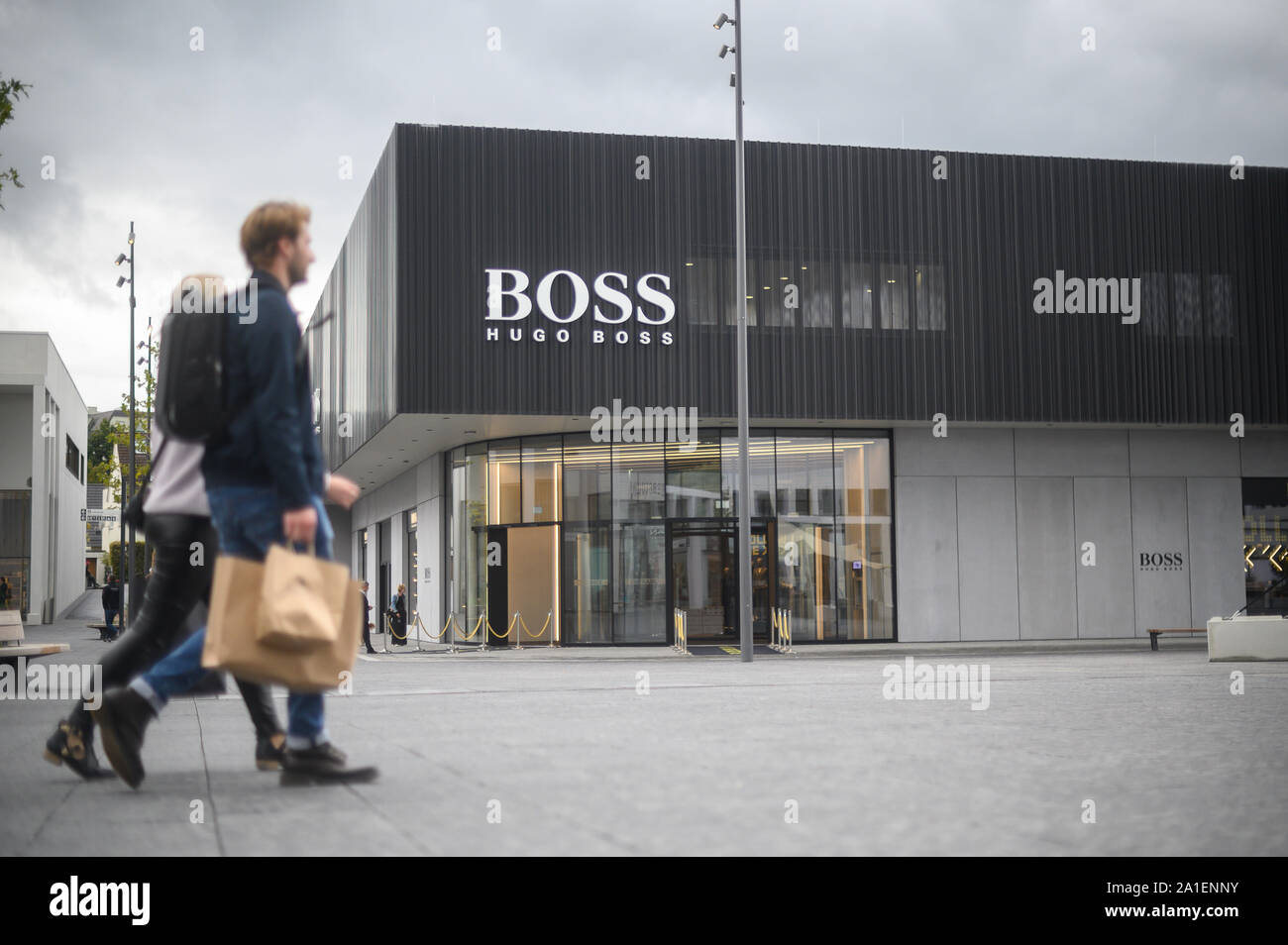 Oprechtheid Wijden vers 26 September 2019, Baden-Wuerttemberg, Metzingen: Visitors pass the new  flagship outlet of Hugo Boss in the Outlet City. The outlet will officially  open on 26 September. Photo: Sebastian Gollnow/dpa Stock Photo - Alamy