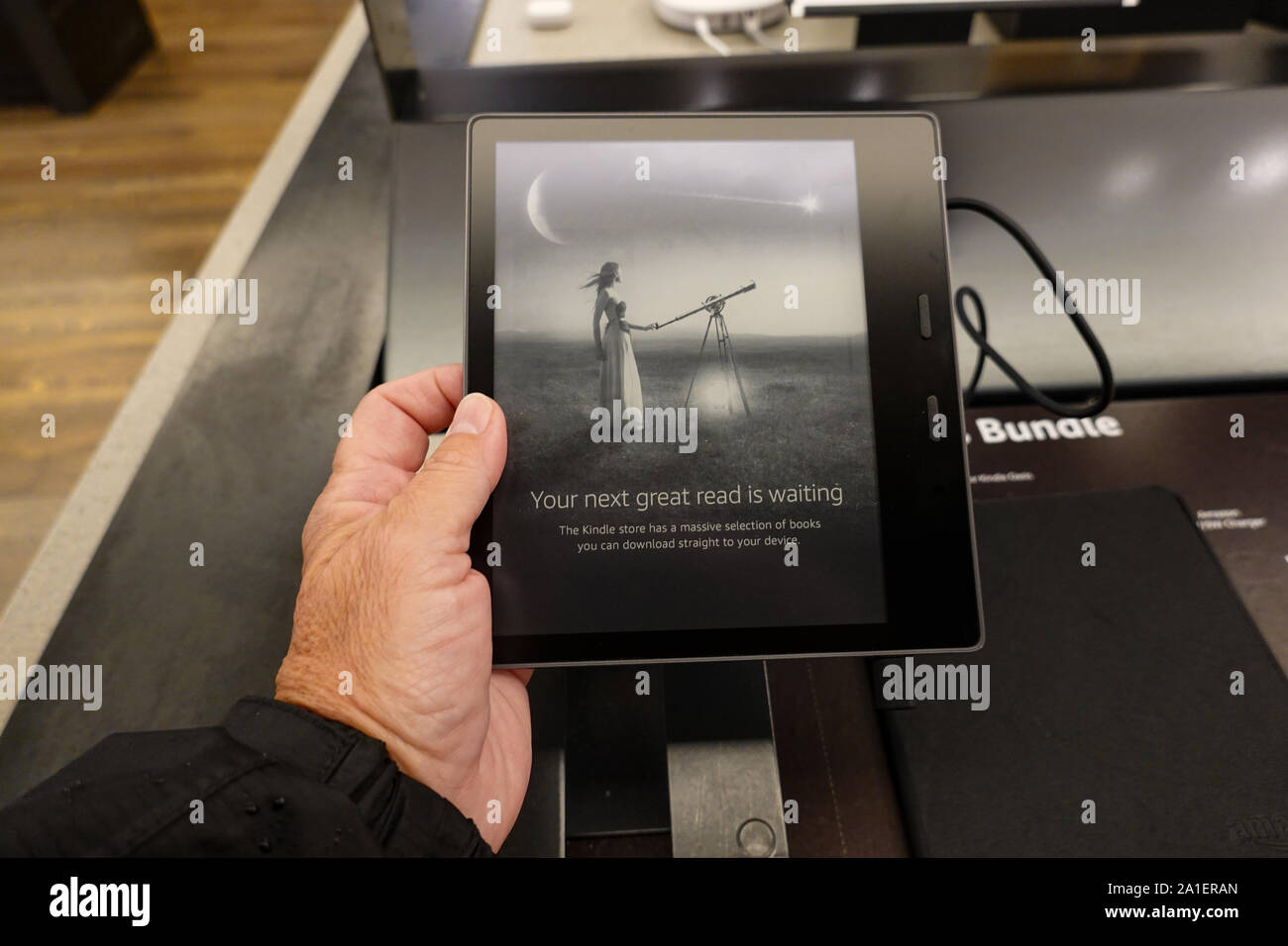 Seattle, WA/USA-6/15/19: A person holding an  Amazon Kindle Oasis device that is on sale at an Amazon Book Store. Stock Photo