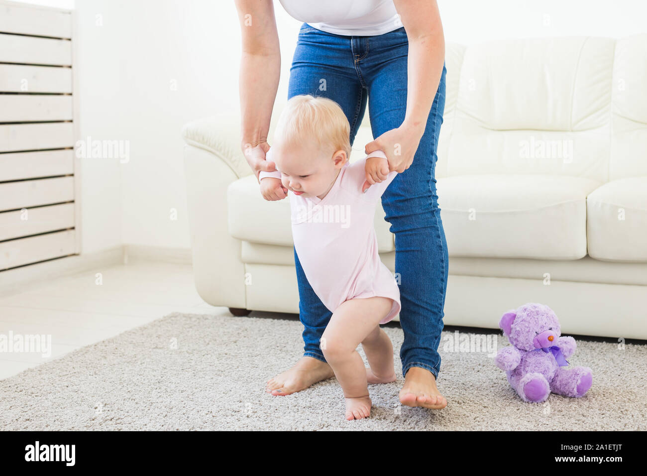 Learning Baby Step First steps. Little baby girl learning to walk. Studio shoot on white ...