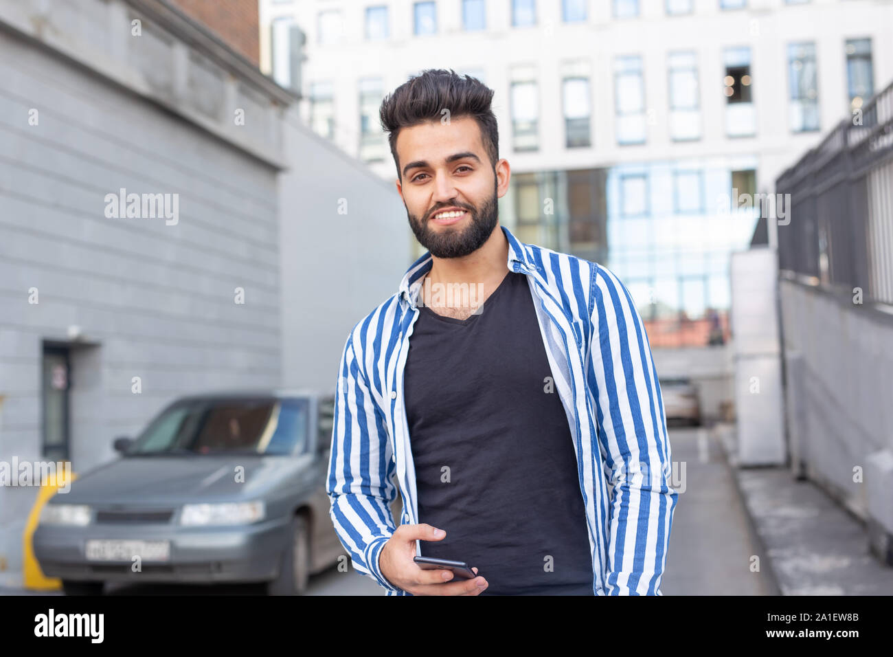 Modern arab young man with mobile phone in the street. Outdoor portrait Stock Photo