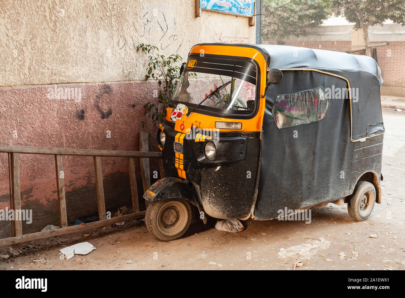 Alexandria, Egypt - December 18, 2018: Yellow black auto rickshaw stands parked on a street Stock Photo