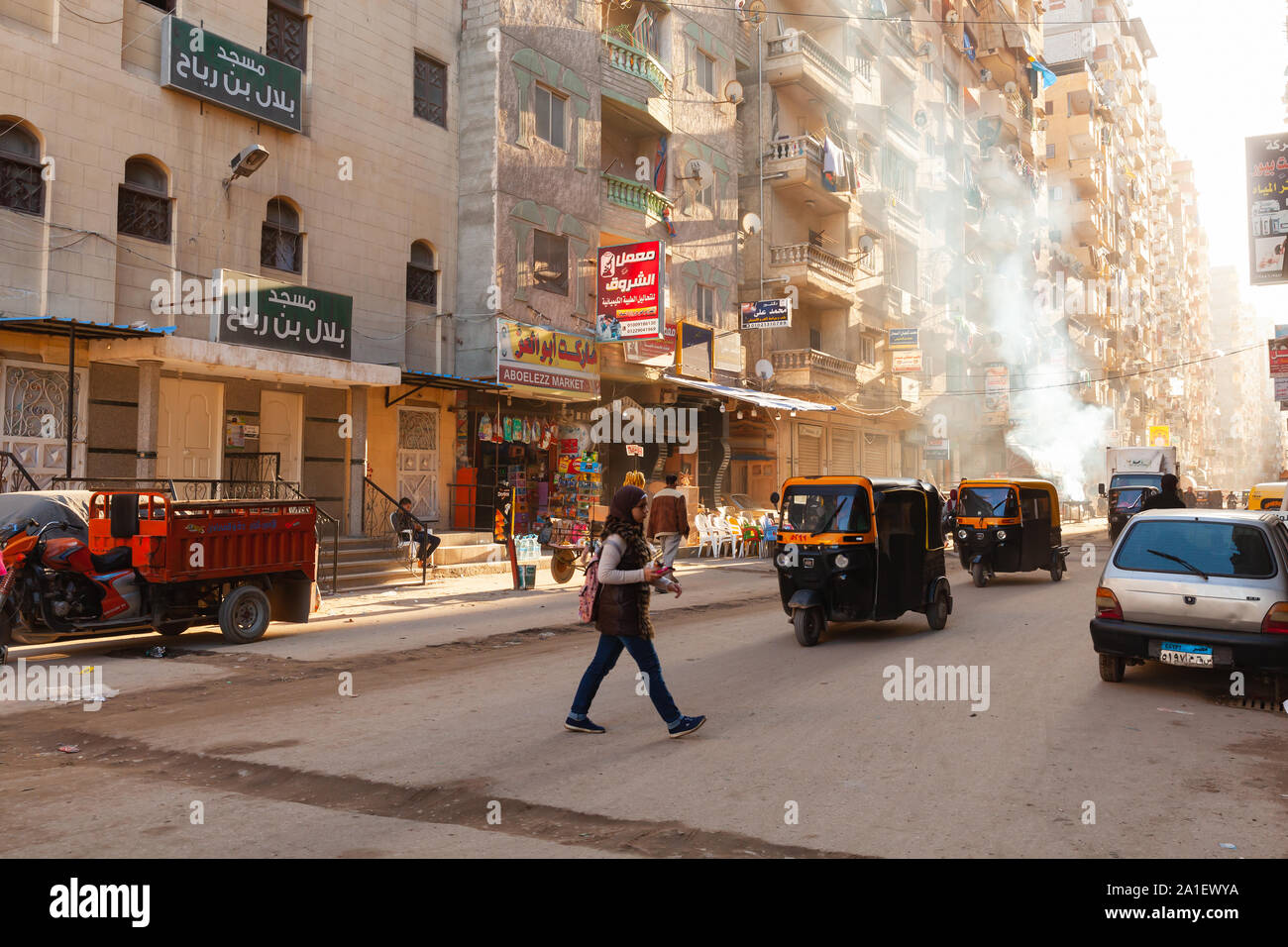 Alexandria, Egypt - December 18, 2018: Alexandria street view, ordinary people walk the street with auto rickshaws and cars Stock Photo